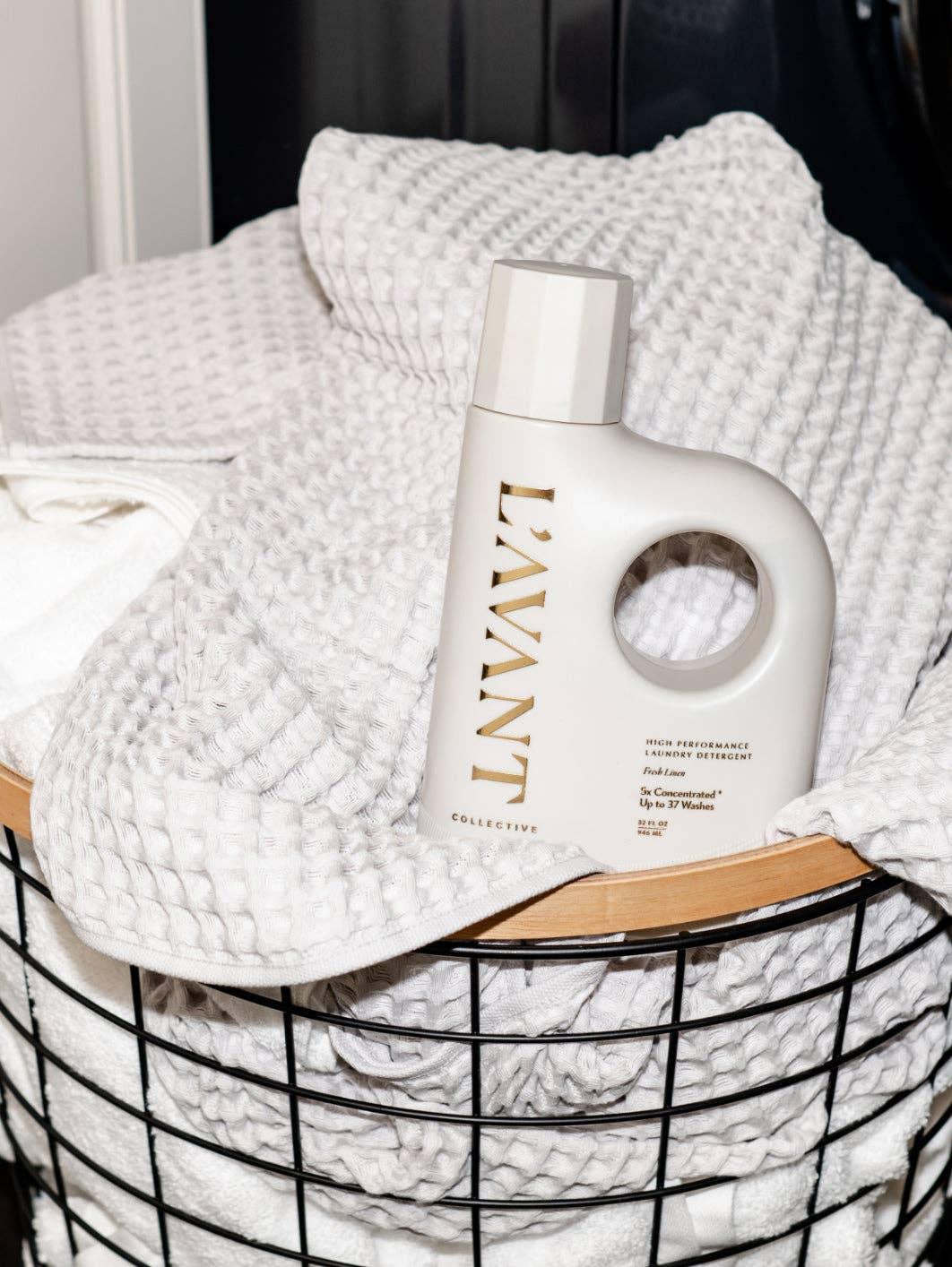 L'AVANT laundry detergent on white towels in a laundry basket, Come see us at Awaken, Franklin, Tennessee