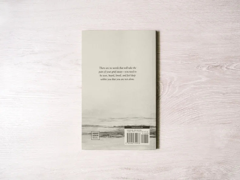 Back cover of a book with a heartfelt quote, barcode, and Thought Catalog Books logo on wood surface. Come see us at Awaken, Franklin, Tennessee