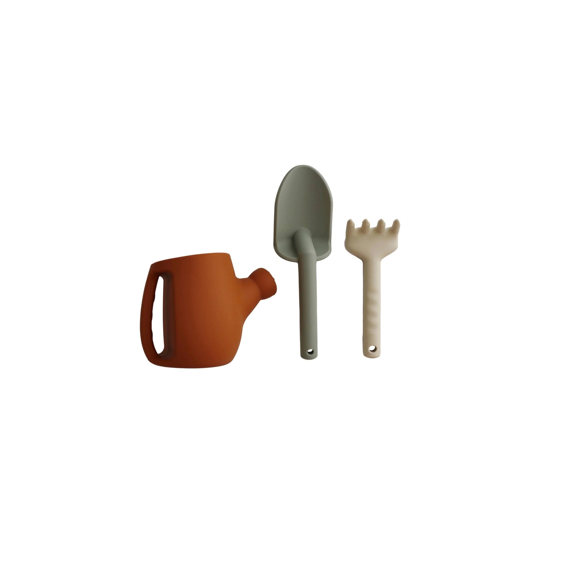 Kids gardening set with orange watering can, green shovel, and beige rake on white background. Come see us at Awaken, Franklin, Tennessee