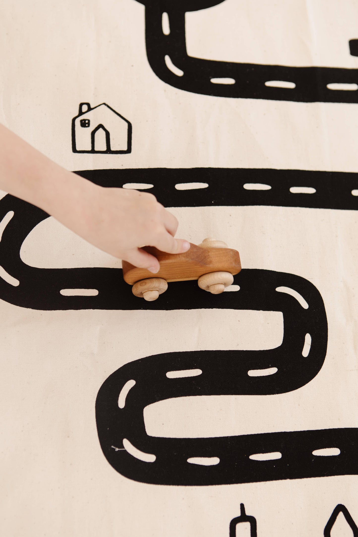 Child playing with wooden toy car on play mat road, Come see us at Awaken, Franklin, Tennessee
