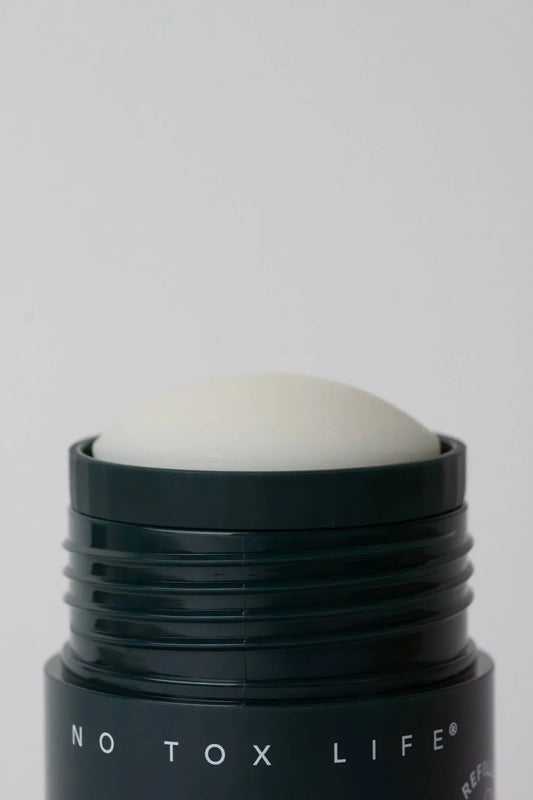Close-up of deodorant stick labeled No Tox Life against plain background. Come see us at Awaken, Franklin, Tennessee