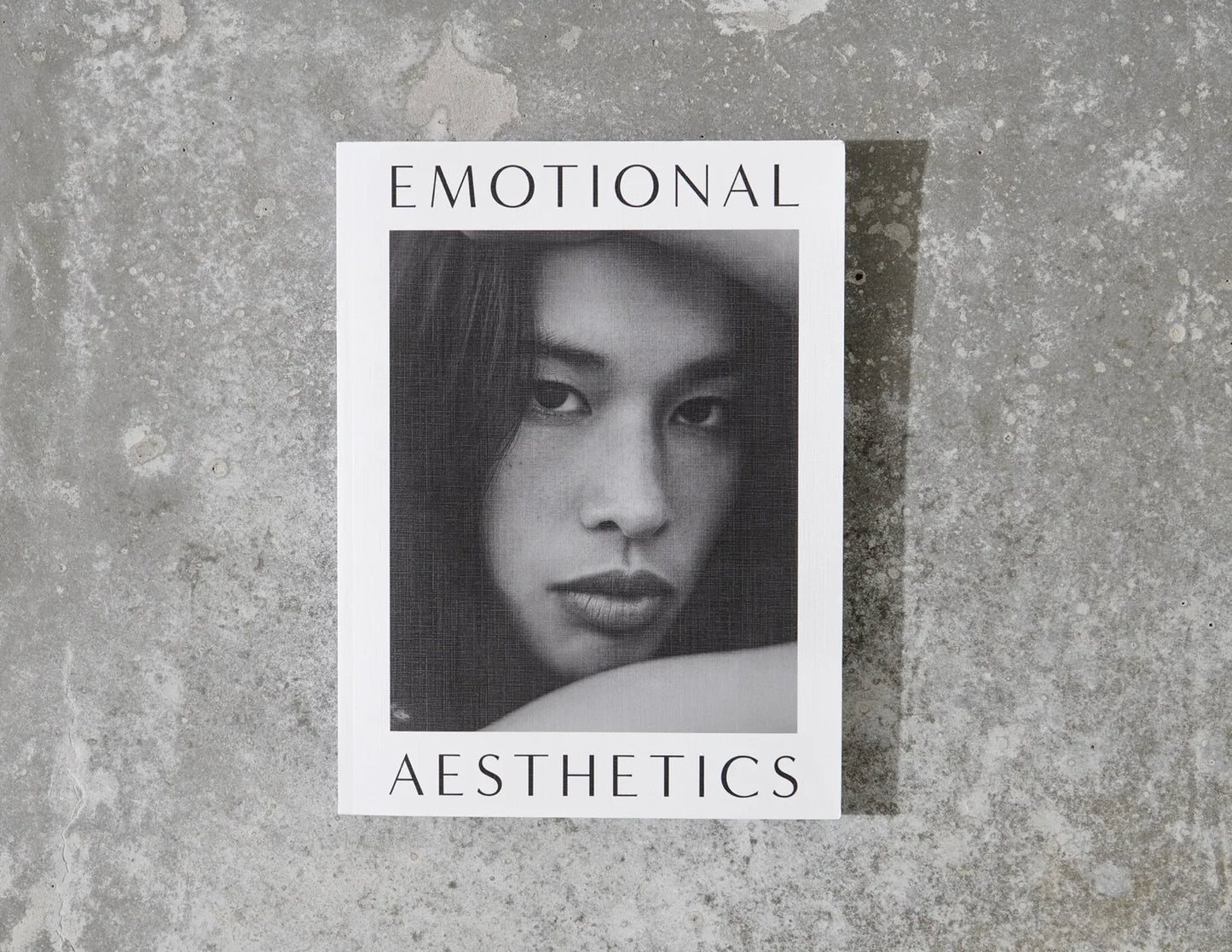 Emotional Aesthetics book with black and white portrait on textured concrete background. Come see us at Awaken, Franklin, Tennessee