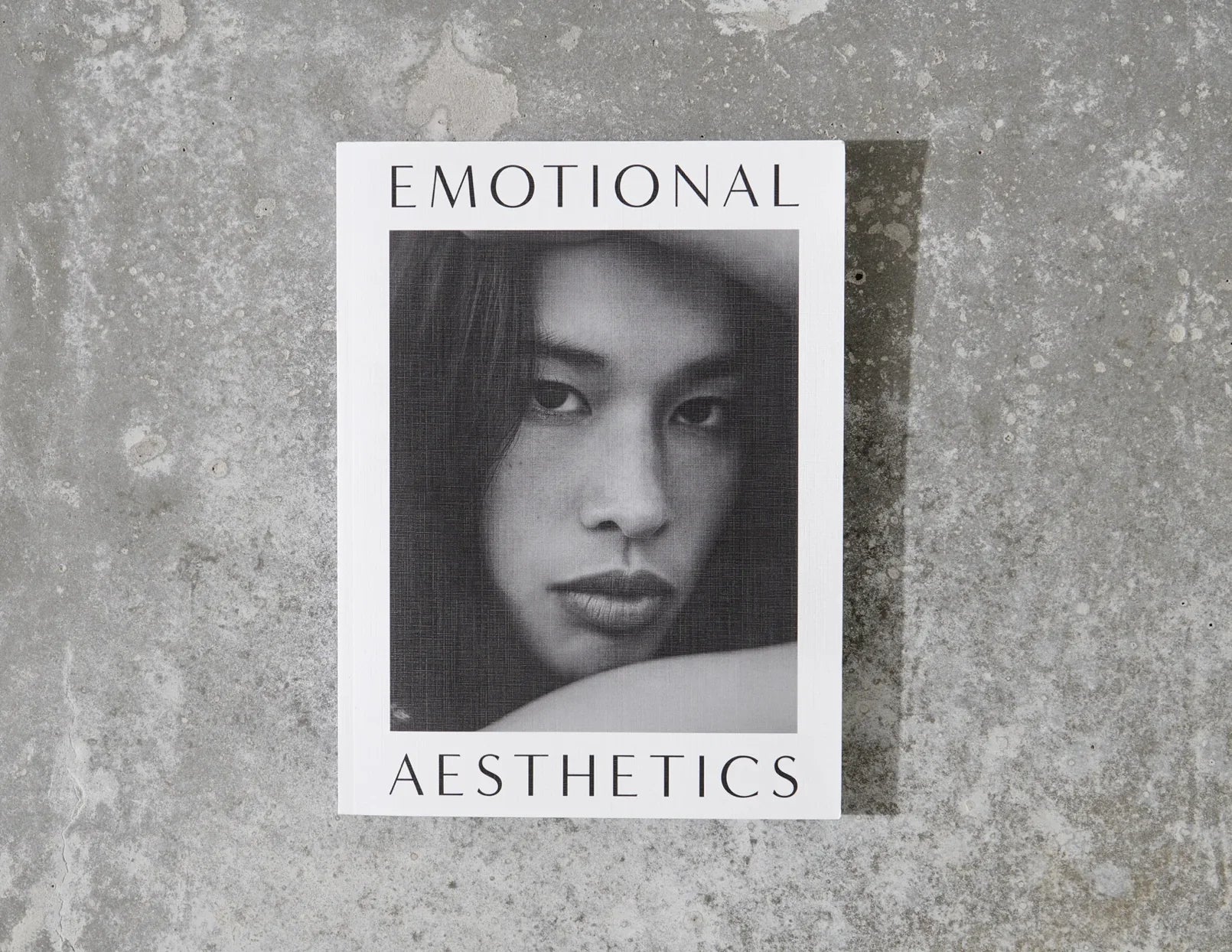 Emotional Aesthetics book with black and white portrait on textured concrete background. Come see us at Awaken, Franklin, Tennessee
