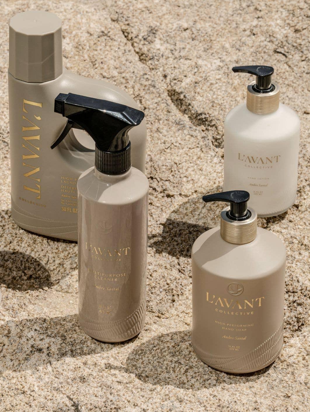 L'Avant Collective beige cleaning products on textured stone surface with black and gold accents. Come see us at Awaken, Franklin, Tennessee