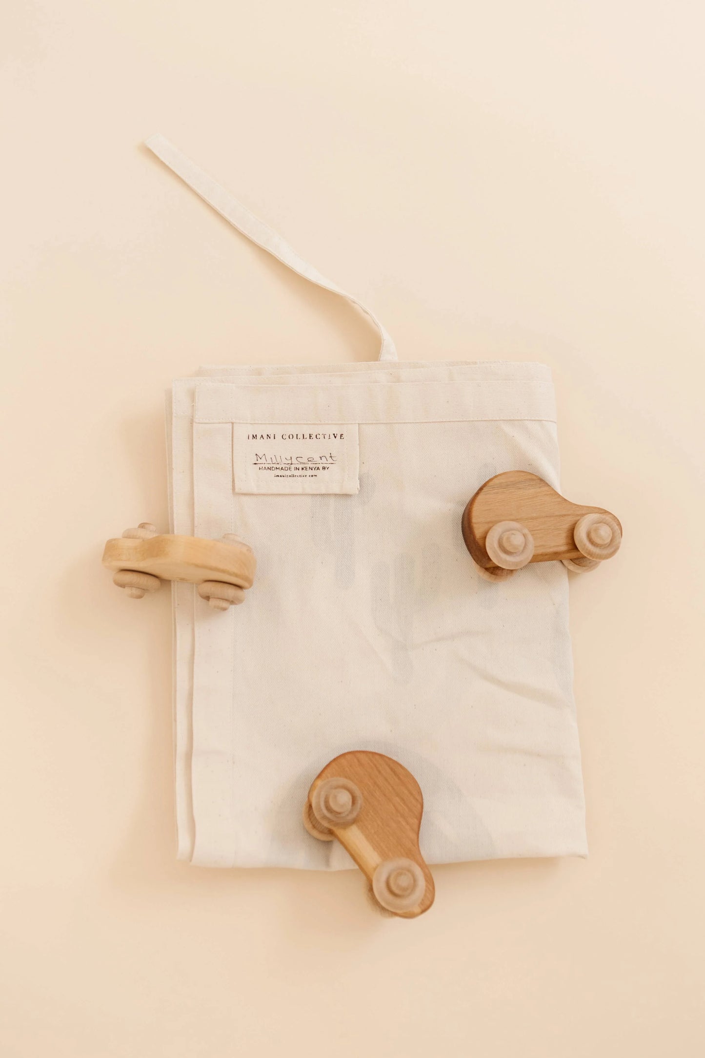 Wooden toy cars on a beige cloth bag, Come see us at Awaken, Franklin, Tennessee