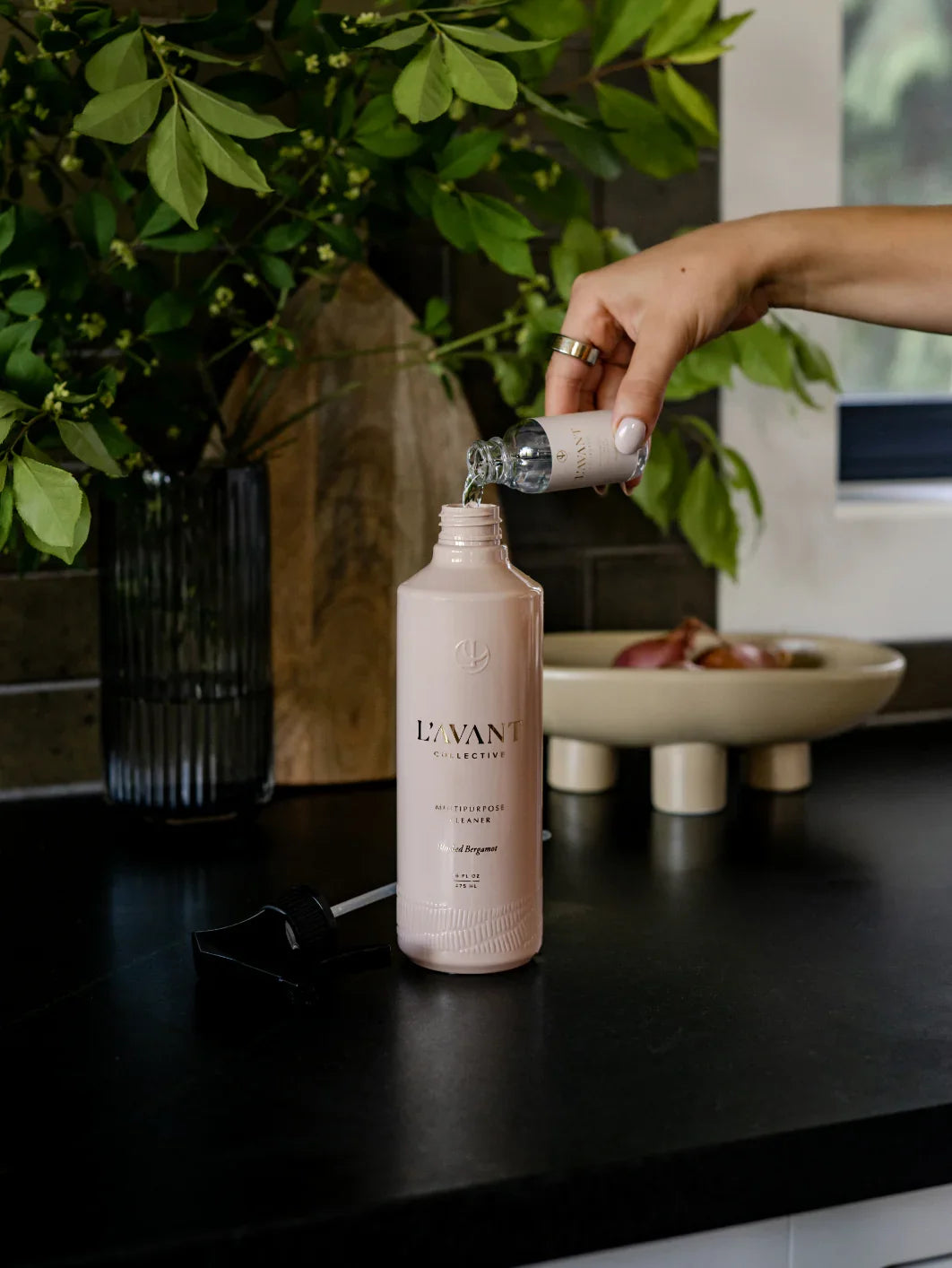 Hand pouring L'AVANT Collective cleaner refill in kitchen, Come see us at Awaken, Franklin, Tennessee