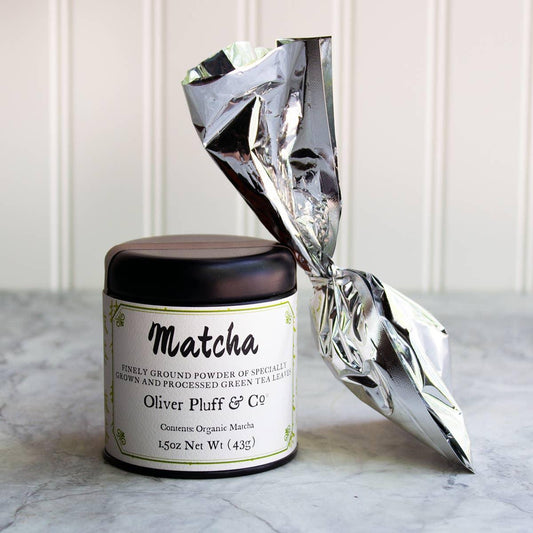 Oliver Pluff matcha organic green tea powder tin with silver foil pouch on marble surface. Come see us at Awaken, Franklin, Tennessee