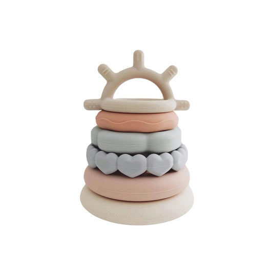 Stacked silicone baby teething rings in pastel colors and shapes, safe infant toy. Come see us at Awaken, Franklin, Tennessee