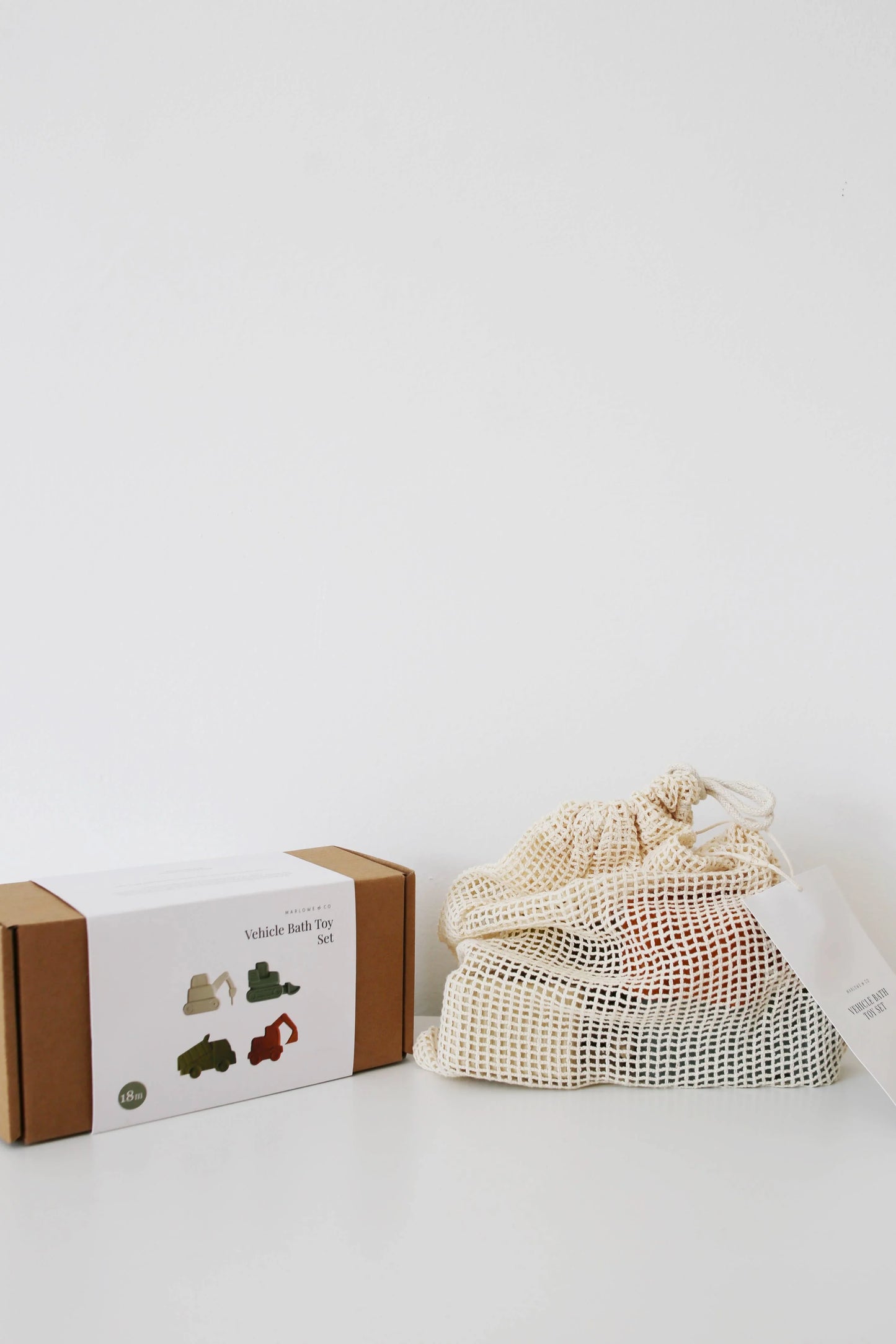 Vehicle Bath Toy Set packaging and mesh bag with toys on white surface, minimal background. Come see us at Awaken, Franklin, Tennessee