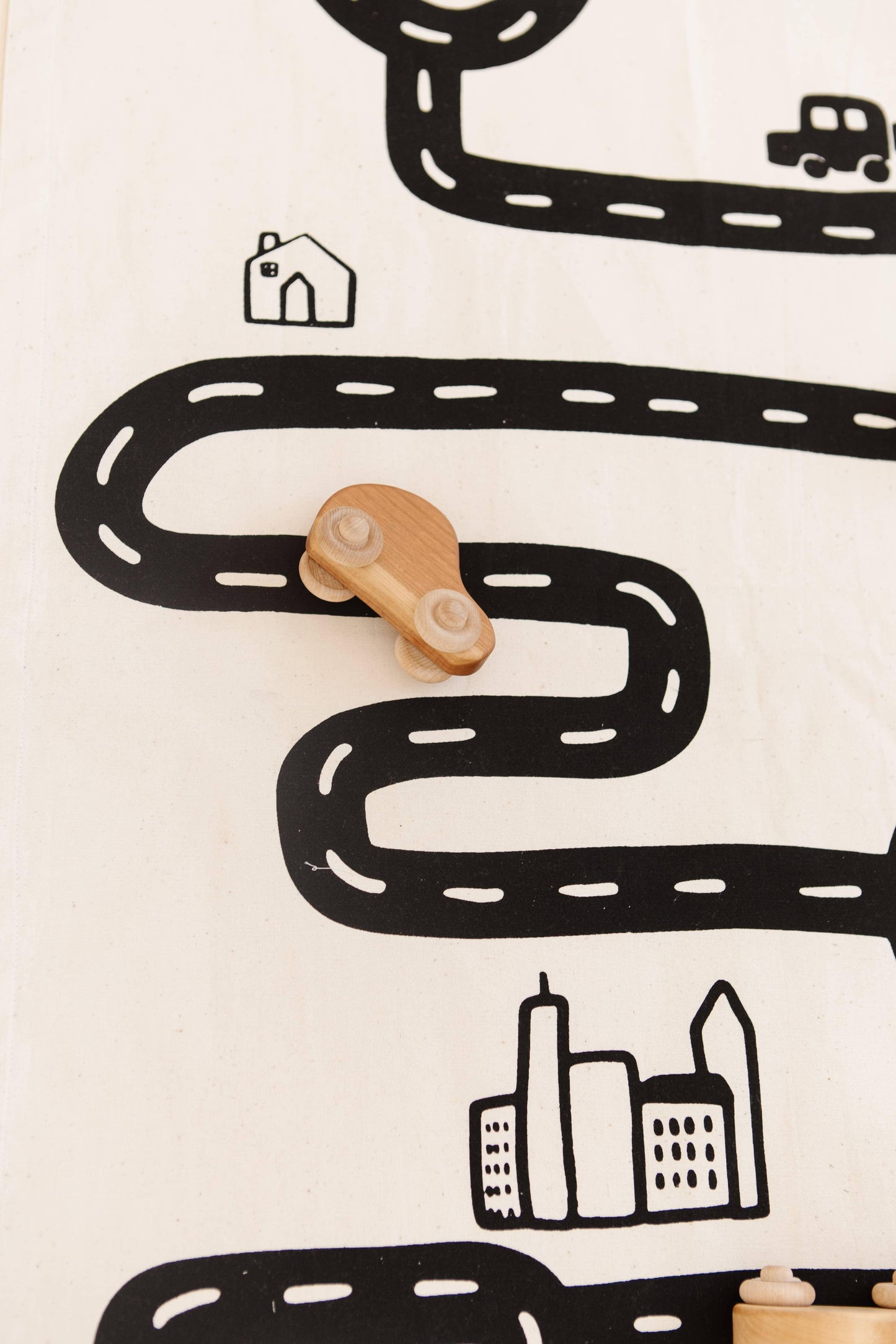 Wooden toy car on illustrated road map with house and city, Come see us at Awaken, Franklin, Tennessee