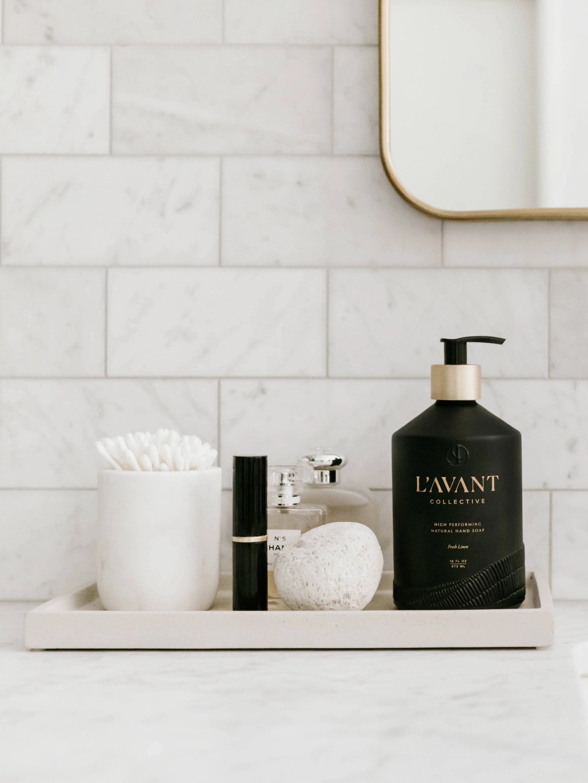 Modern bathroom counter with L'Avant soap, stone, cotton swabs on tray. Come see us at Awaken, Franklin, Tennessee.