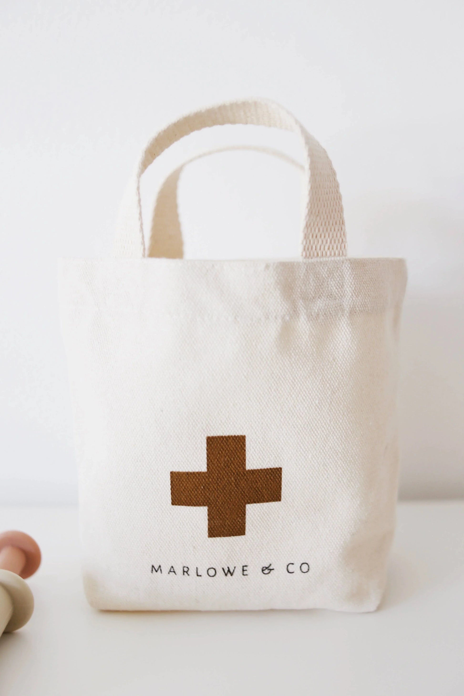 Small natural canvas tote bag with brown cross and Marlowe & Co logo. Come see us at Awaken, Franklin, Tennessee