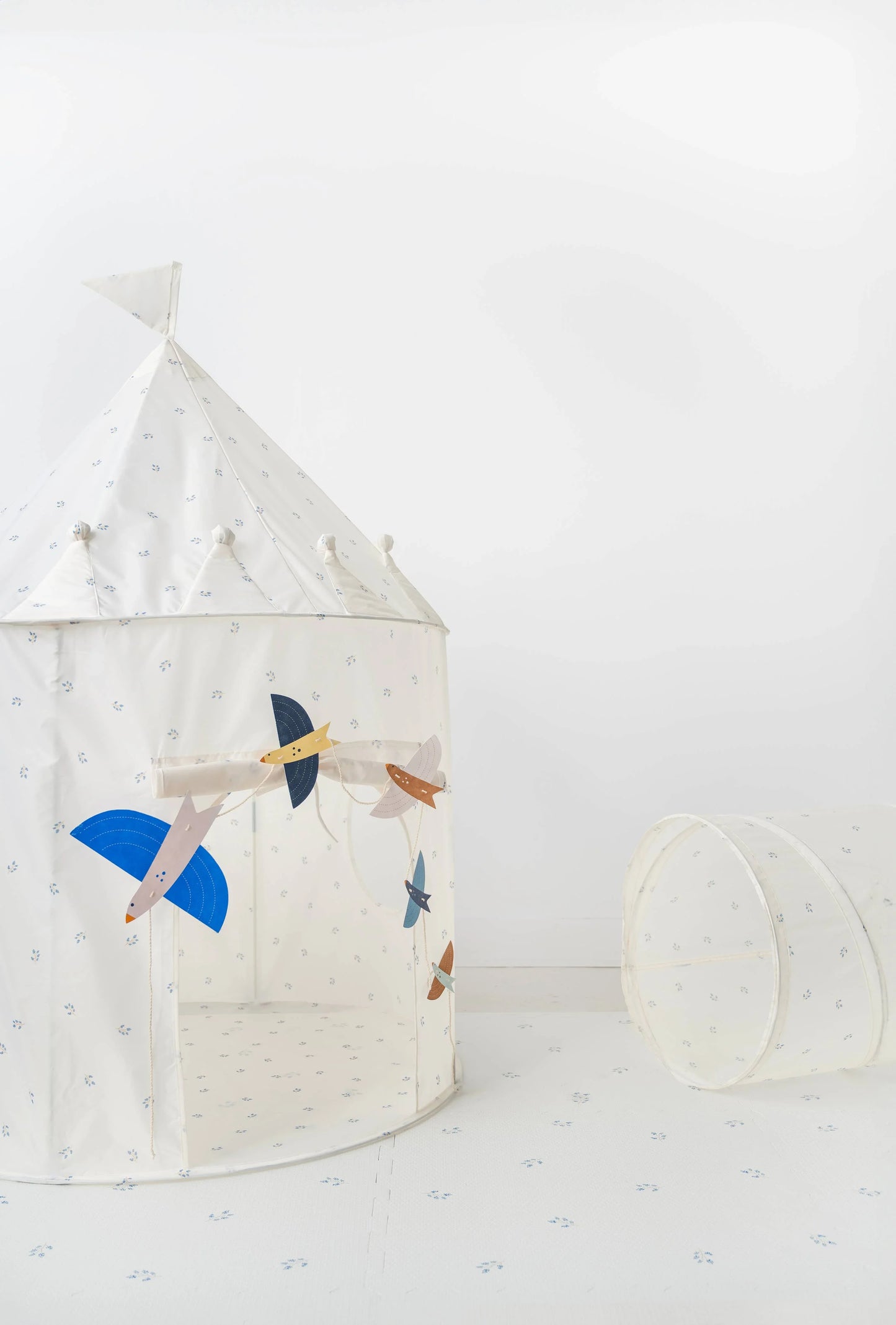 White children's play tent with bird decorations and matching tunnel in minimal room. Come see us at Awaken, Franklin, Tennessee