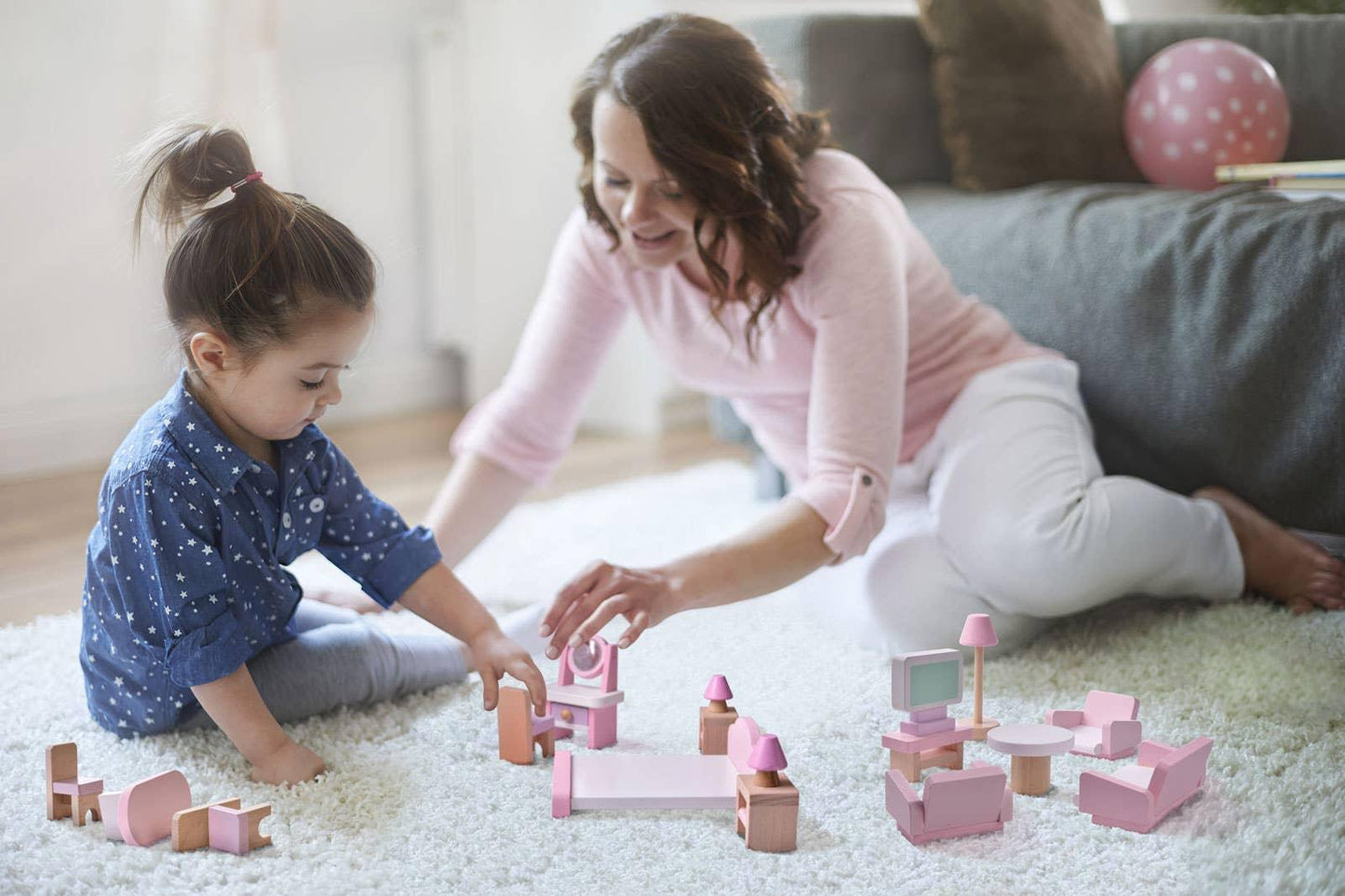 Mother and daughter playing with pink dollhouse furniture on carpet, Come see us at Awaken, Franklin, Tennessee