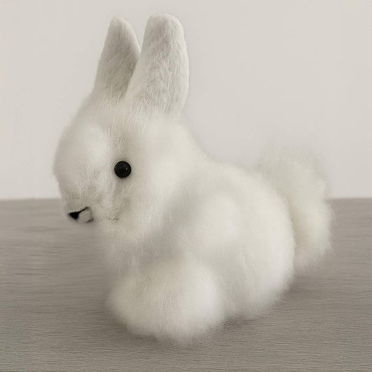 Fluffy white bunny decor with black eyes on wood table, soft texture. Come see us at Awaken, Franklin, Tennessee