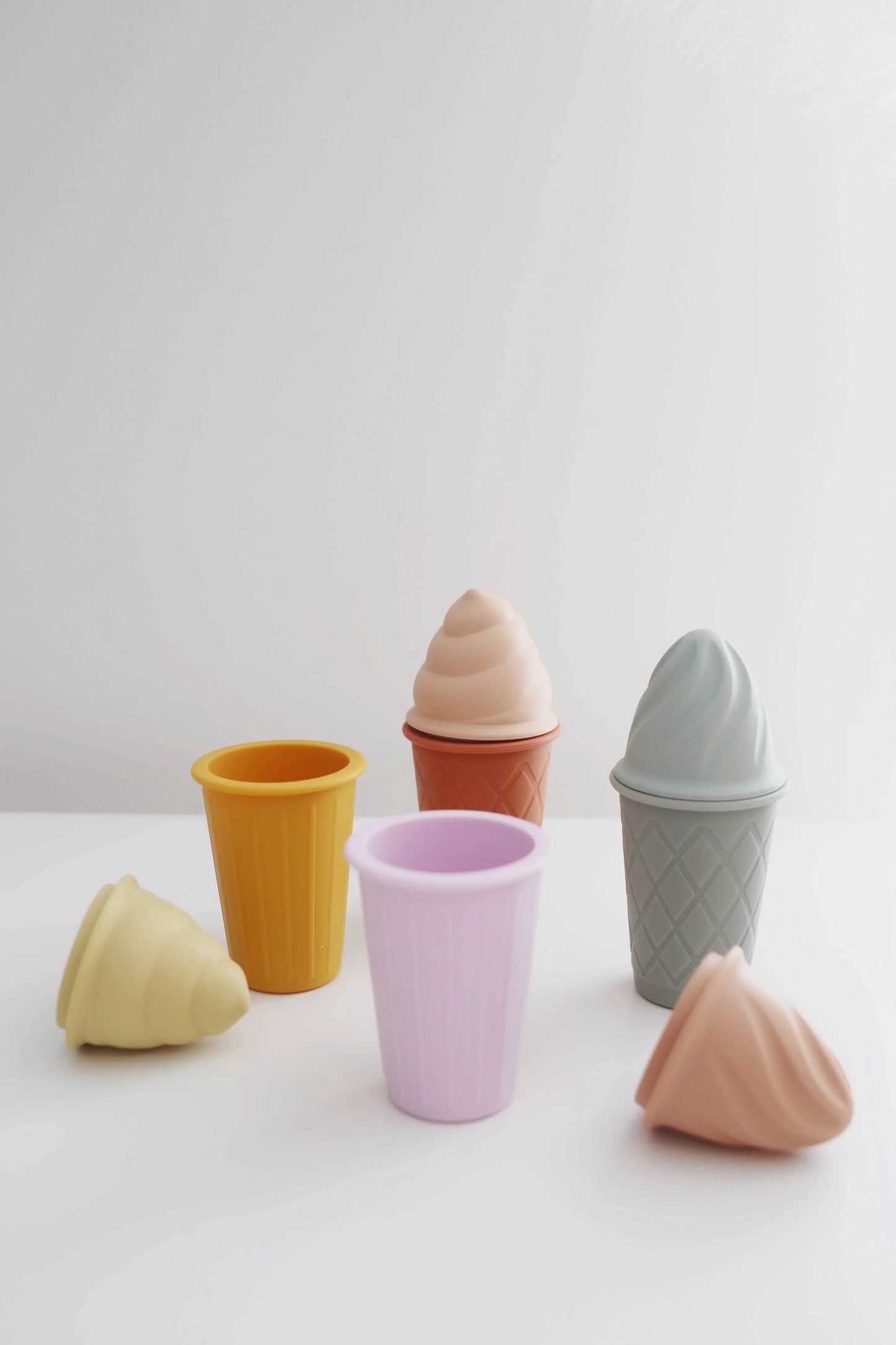 Colorful silicone ice cream cones and cups in pastel shades on white surface. Come see us at Awaken, Franklin, Tennessee