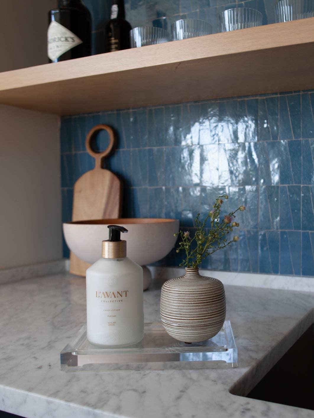 L'AVANT Collective hand soap and striped vase on marble kitchen counter, blue tile backsplash, Come see us at Awaken, Franklin, Tennessee
