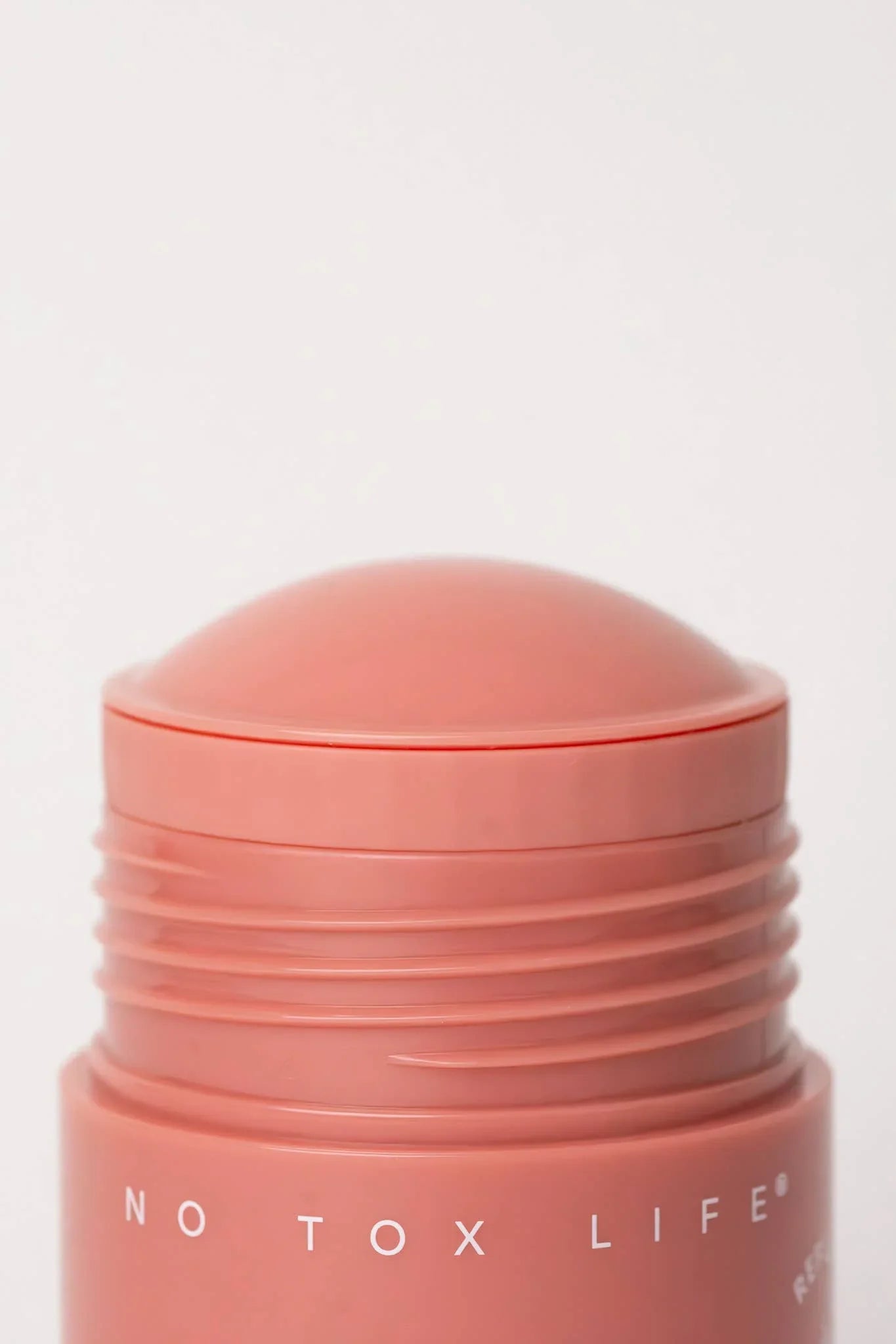 Close-up of peach-colored No Tox Life deodorant stick with rounded top, clean background. Come see us at Awaken, Franklin, Tennessee