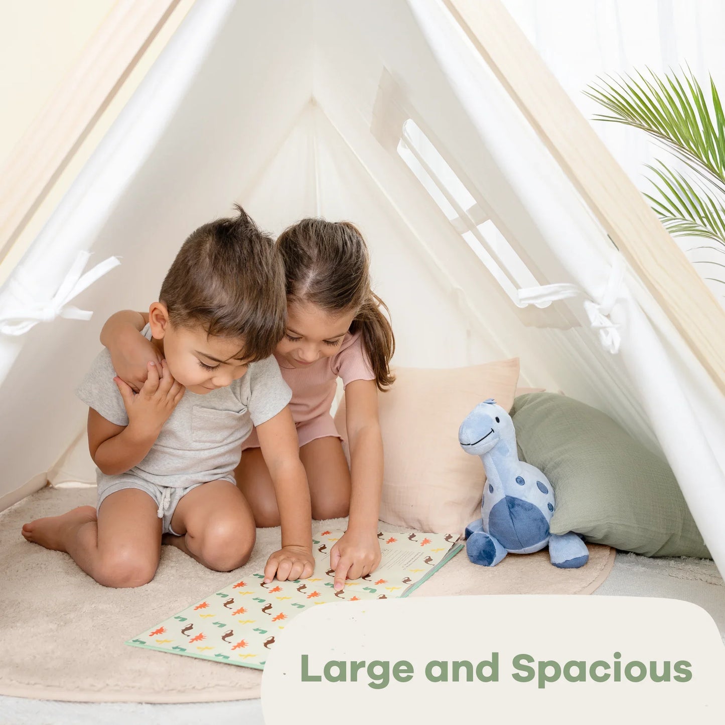 Kids reading in play tent with plush dinosaur toy, cozy pillows, and plant. Large and Spacious. Come see us at Awaken, Franklin, Tennessee.