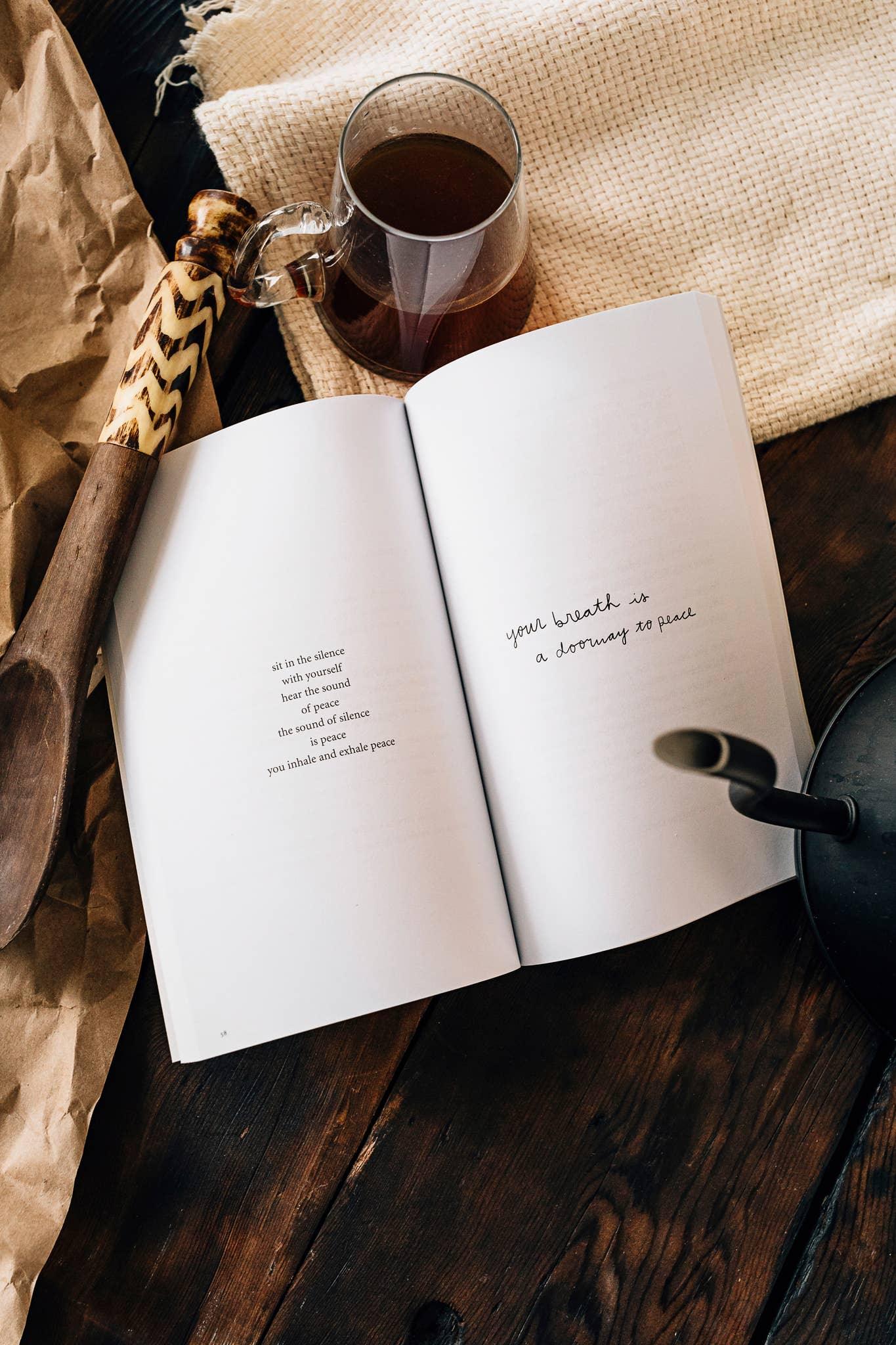 Open book with peaceful poetry on wood table, glass of tea, rustic spoon, and jute cloth; Come see us at Awaken, Franklin, Tennessee