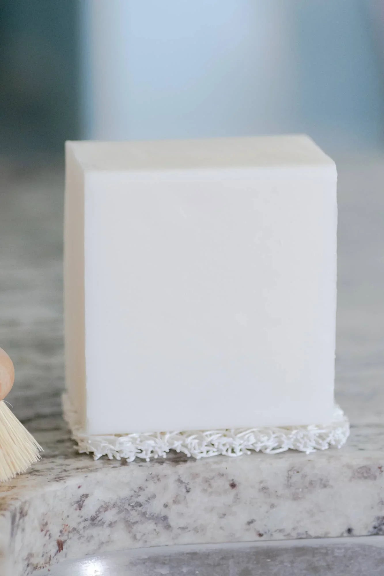 White cake with creamy frosting details on marble countertop, clean modern kitchen. Come see us at Awaken, Franklin, Tennessee