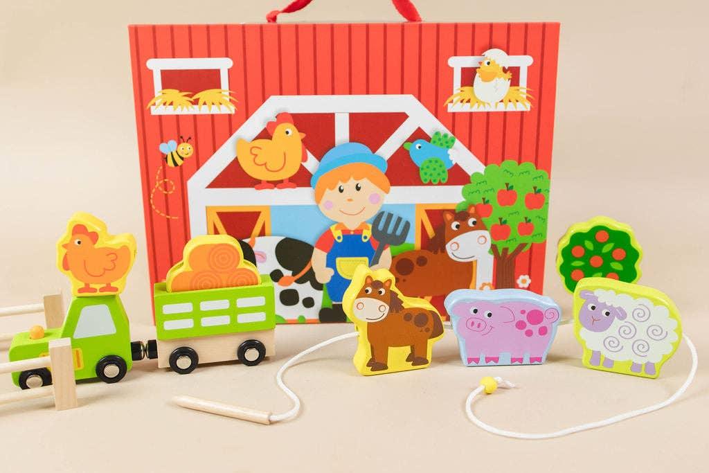 Wooden farm animal toys and tractor with barn backdrop, colorful kids playset. Come see us at Awaken, Franklin, Tennessee