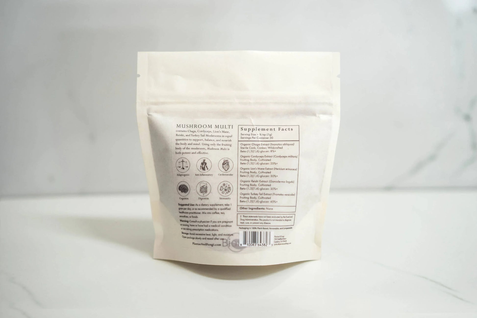 Back of Mushroom Multi supplement bag with ingredients and benefits listed on white marble surface, Come see us at Awaken, Franklin, Tennessee
