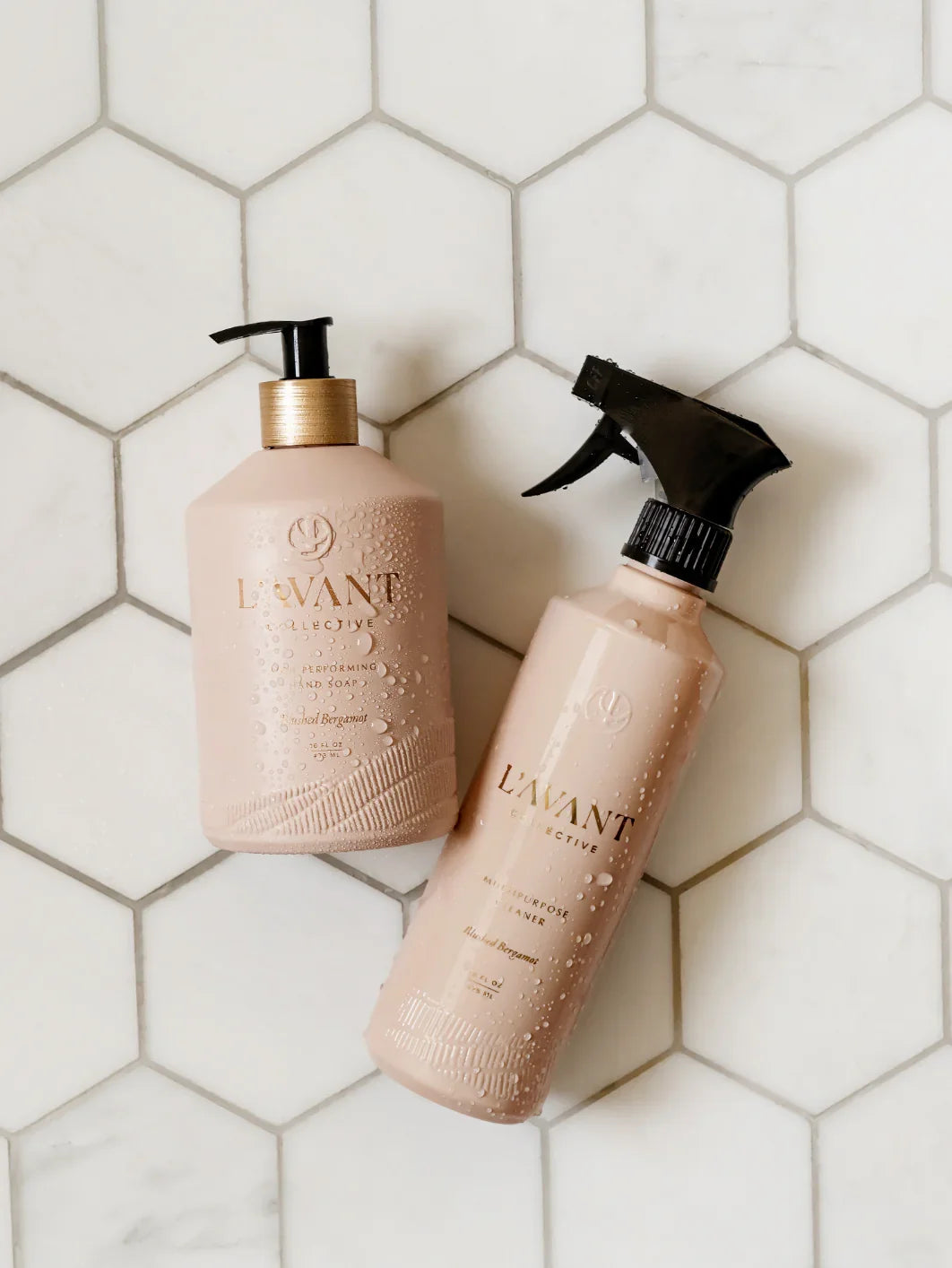L'AVANT Collective hand soap and cleaner bottles with water droplets on white tile, Come see us at Awaken, Franklin, Tennessee