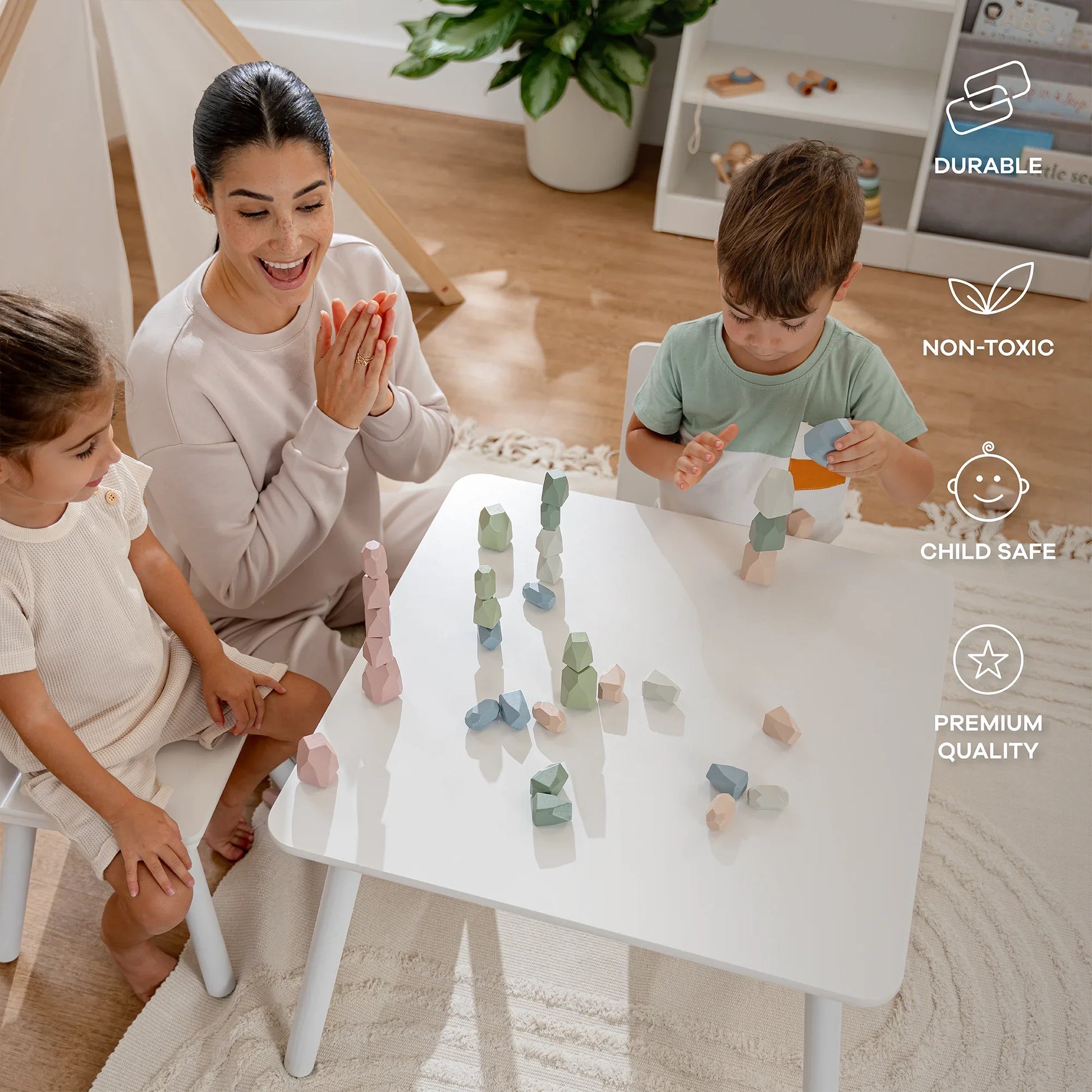 Children and woman playing with pastel wooden stacking toys at white table in bright room. Come see us at Awaken, Franklin, Tennessee
