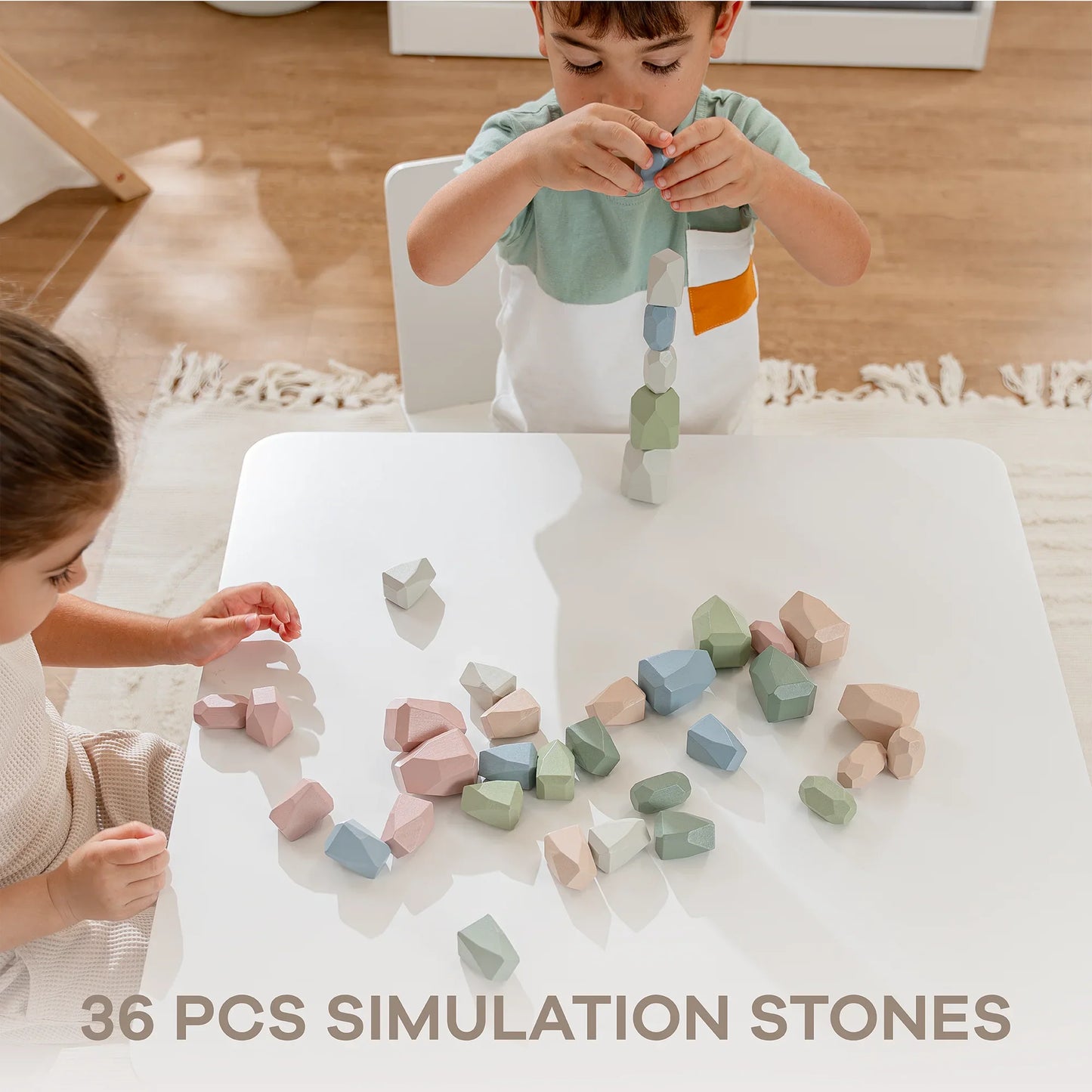 Two children playing with 36 pastel-colored simulation stones on a white table. Come see us at Awaken, Franklin, Tennessee