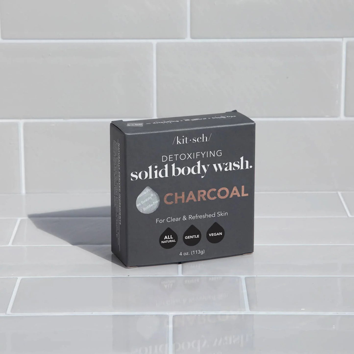 Kitsch detoxifying charcoal solid body wash box on white tile background. Come see us at Awaken, Franklin, Tennessee