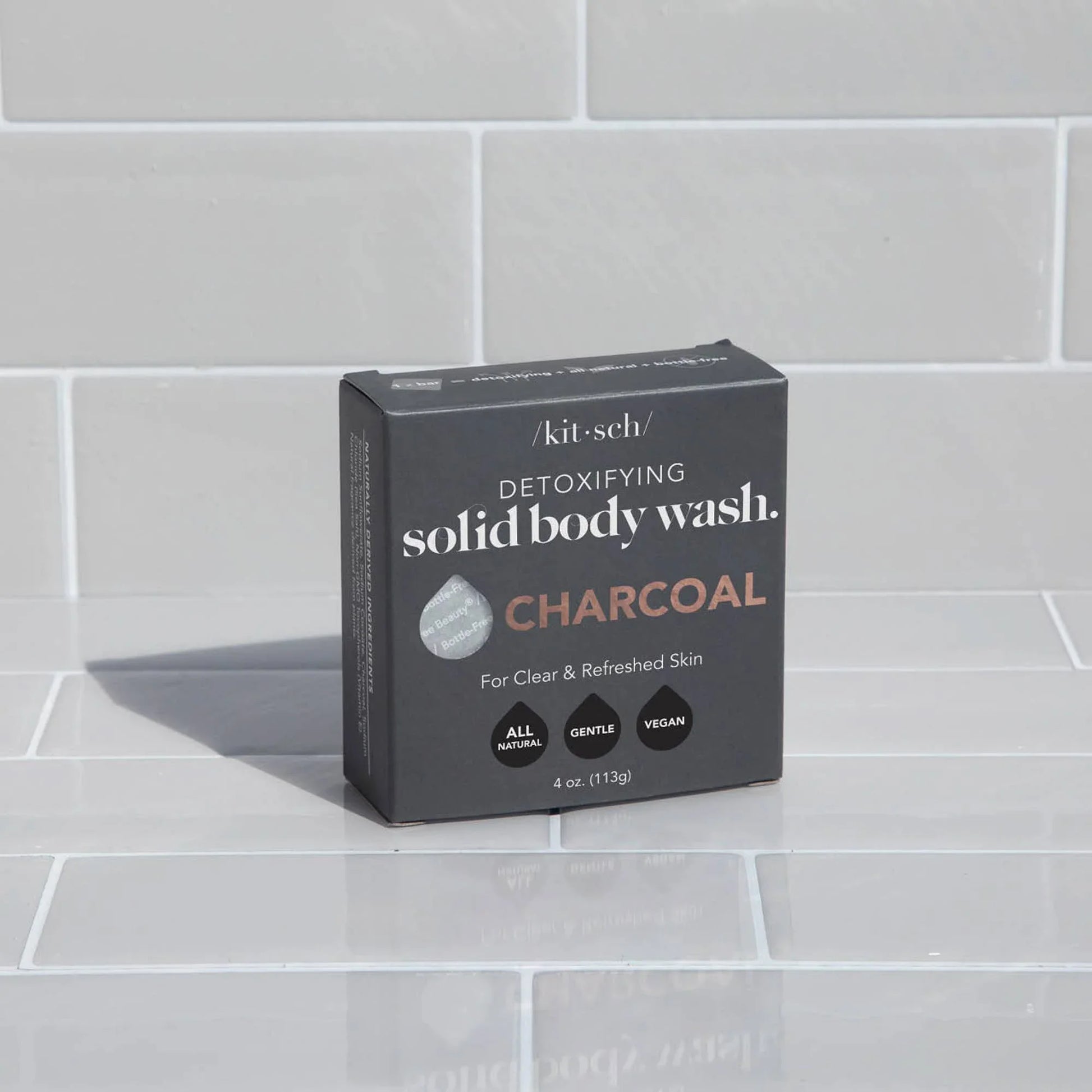 Kitsch detoxifying charcoal solid body wash box on white tile background. Come see us at Awaken, Franklin, Tennessee