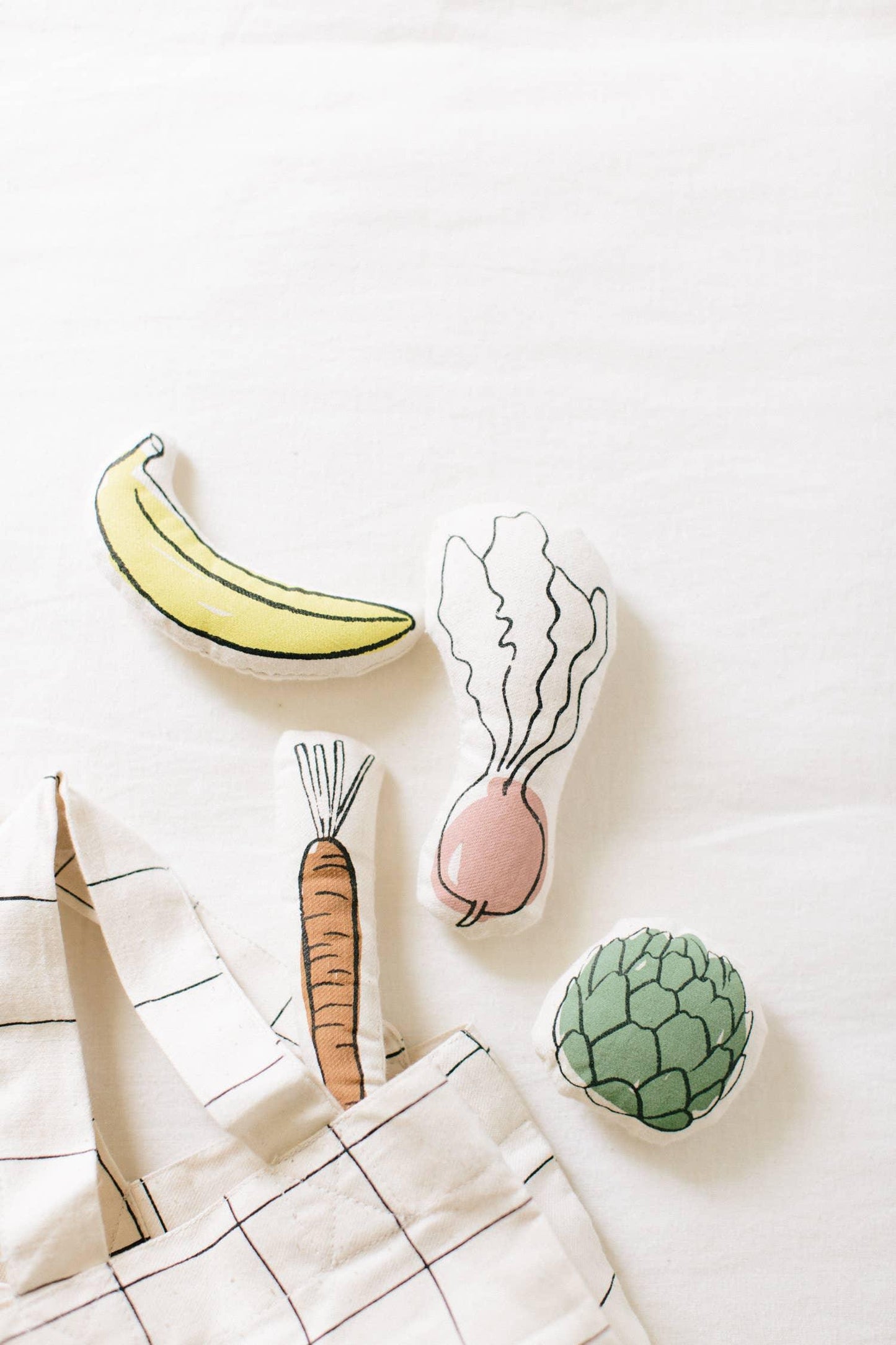 Plush banana, carrot, radish, and artichoke toys with tote bag on white background, Come see us at Awaken, Franklin, Tennessee