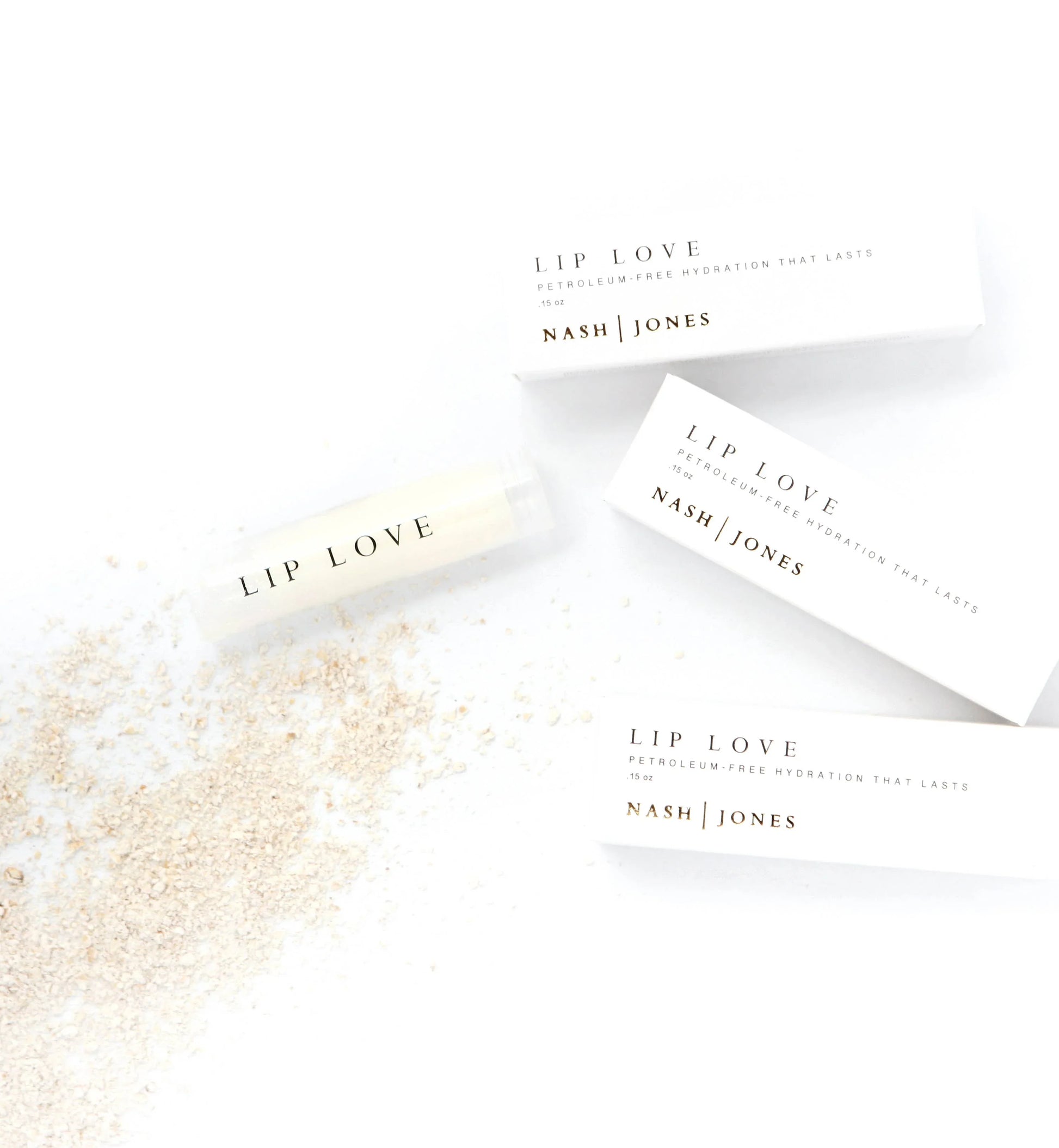 Nash Jones Lip Love petroleum-free lip balm with oat flakes beside packaging. Come see us at Awaken, Franklin, Tennessee