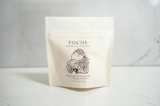Focus mushroom extract powder package on white surface with mushroom illustrations; Come see us at Awaken, Franklin, Tennessee