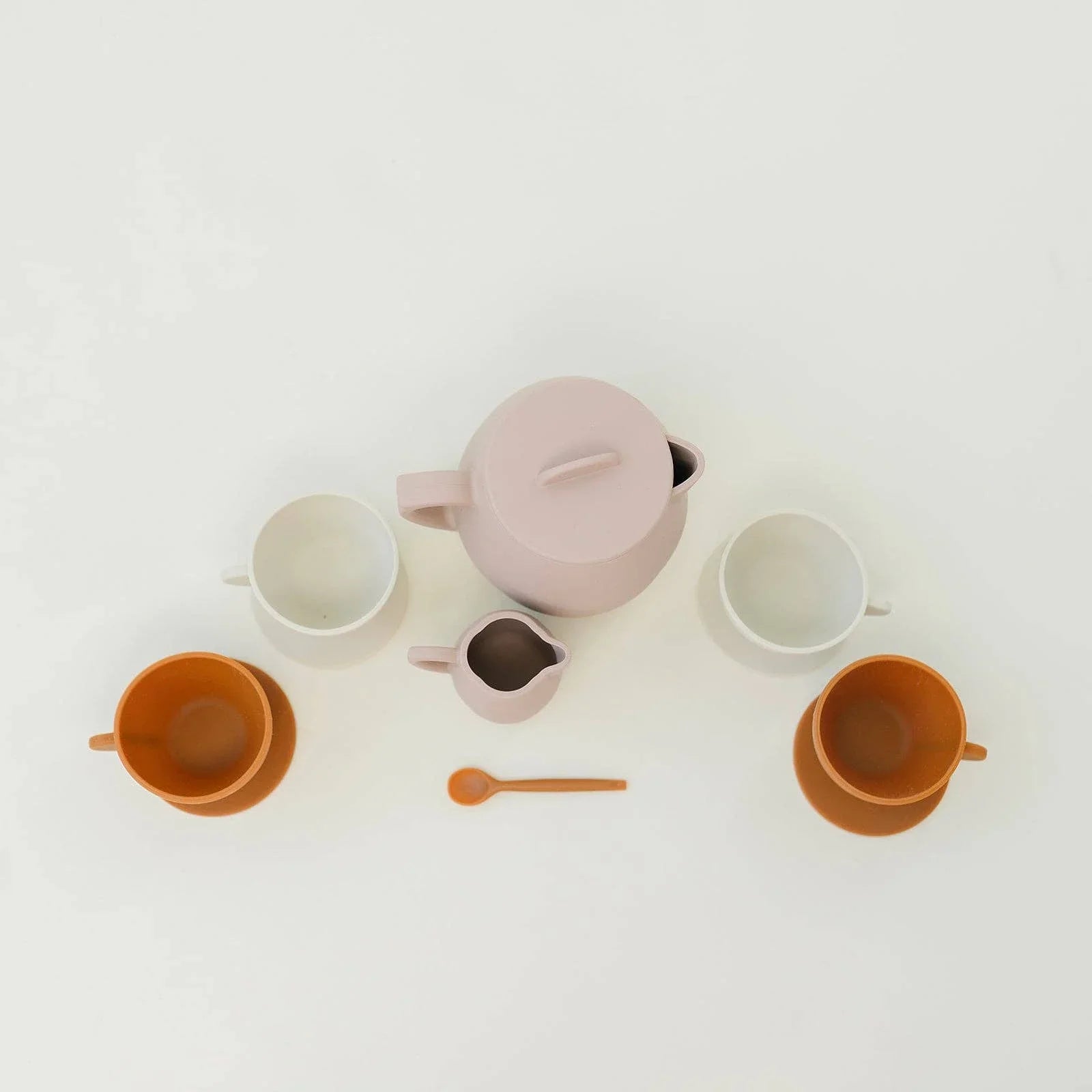 Minimalist ceramic tea set with pastel teapot, cups, and spoon on white background. Come see us at Awaken, Franklin, Tennessee.