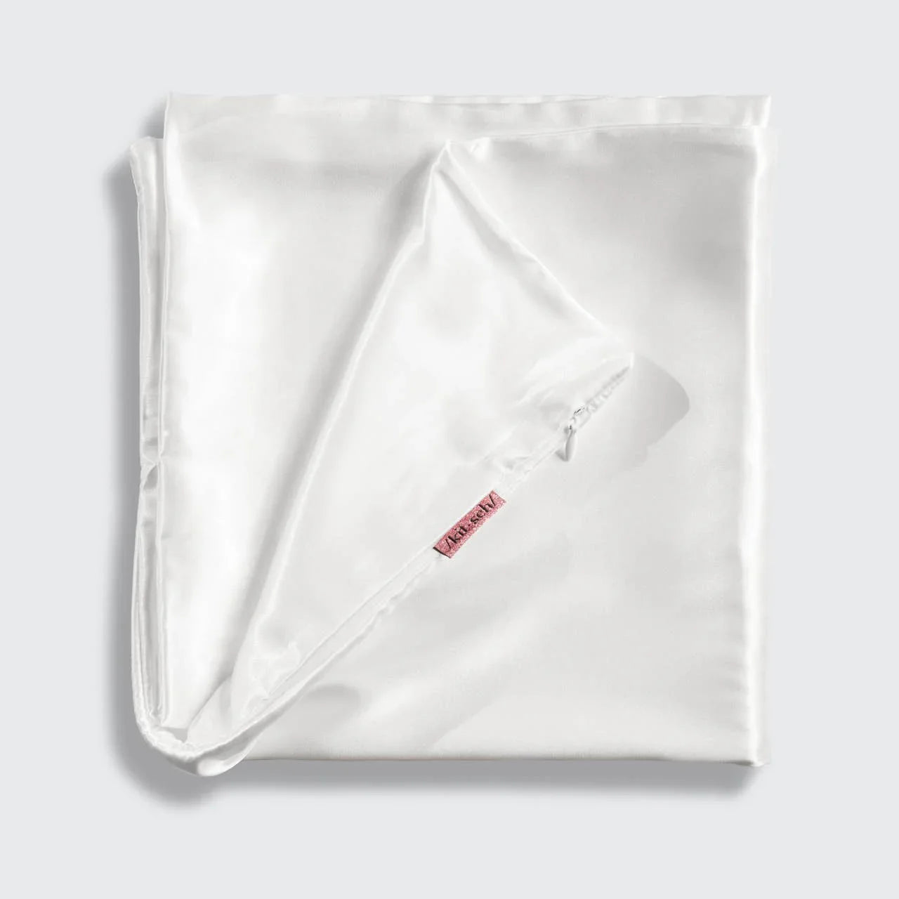Folded white pillowcase with zipper and red label on light background. Come see us at Awaken, Franklin, Tennessee