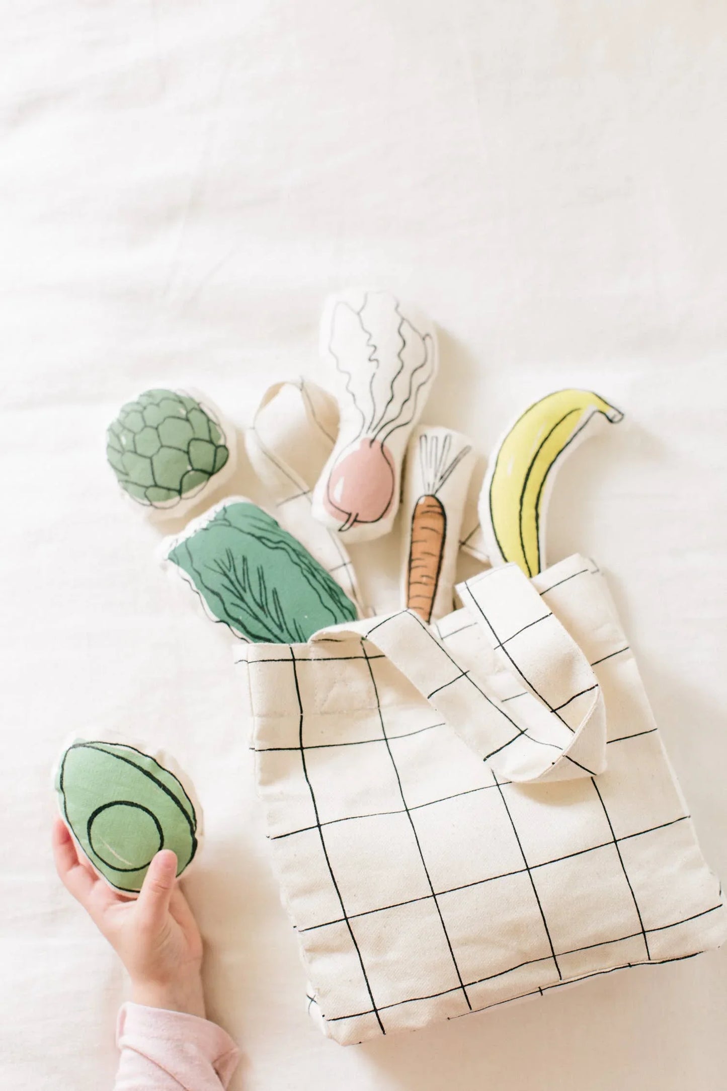 Kids play food plush veggies in grid tote bag, hand holding avocado, Come see us at Awaken, Franklin, Tennessee