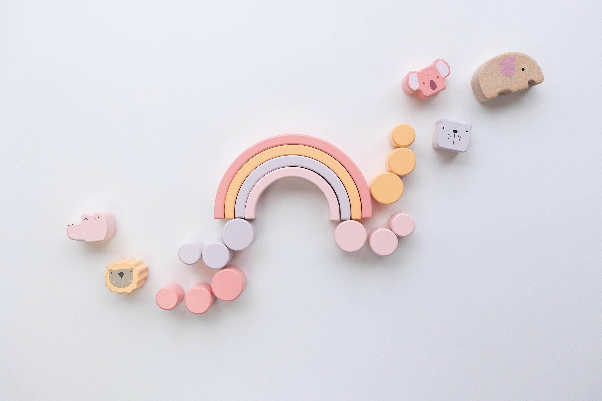 Pastel wooden toy rainbow and animal blocks on white background. Come see us at Awaken, Franklin, Tennessee