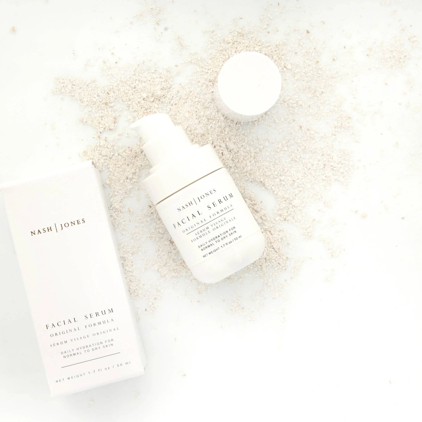Nash Jones facial serum with box on white surface and beige powder background. Come see us at Awaken, Franklin, Tennessee