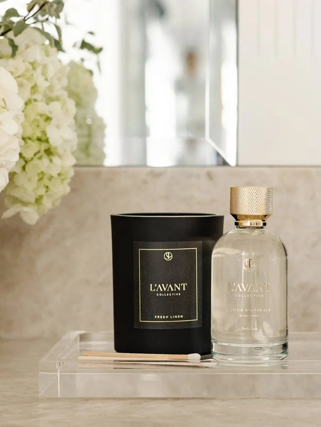 L'AVANT Collective Fresh Linen candle and room spray on bathroom counter with floral decor, Come see us at Awaken, Franklin, Tennessee