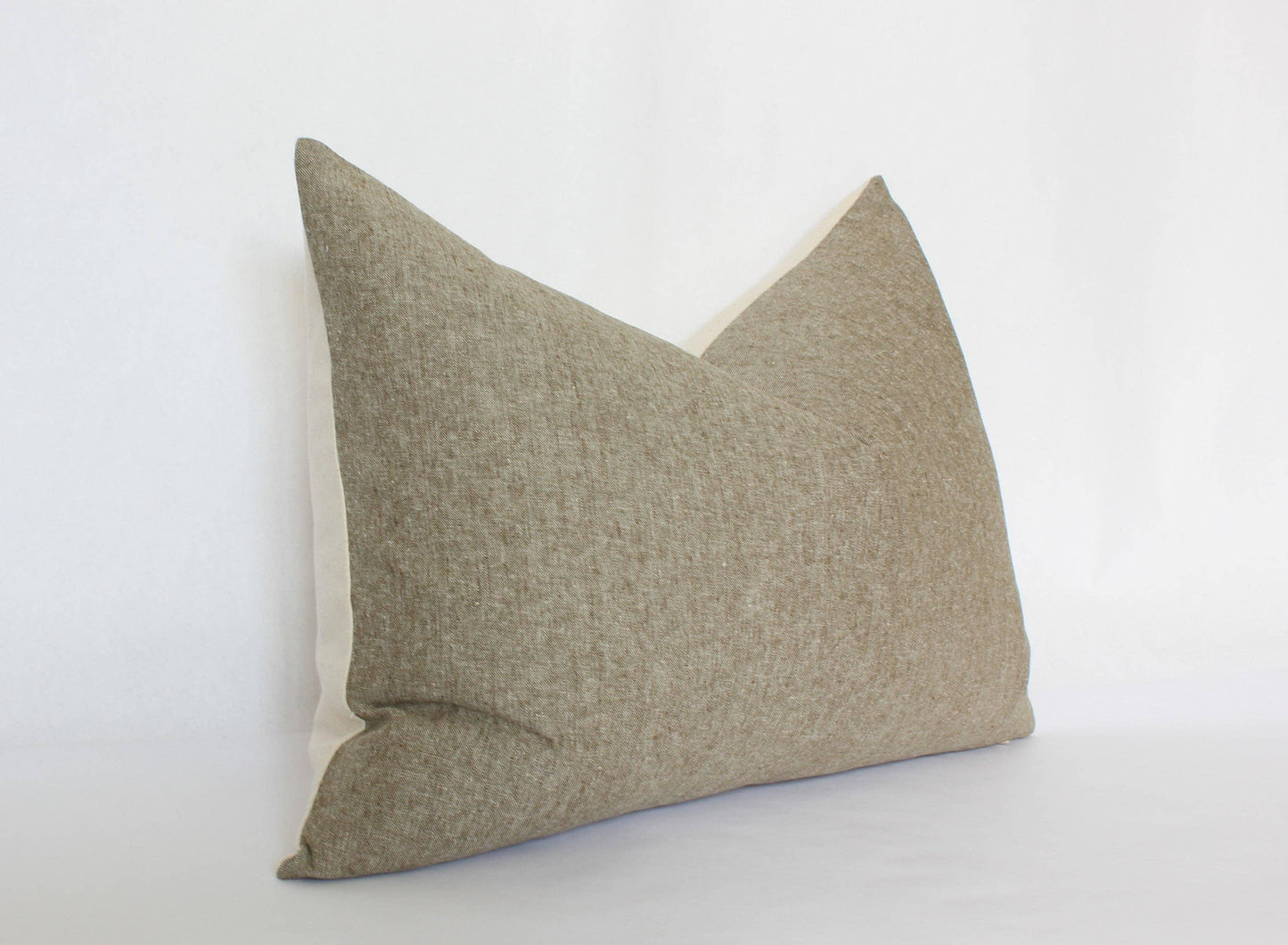 Textured beige lumbar pillow with cream edges on white background. Come see us at Awaken, Franklin, Tennessee