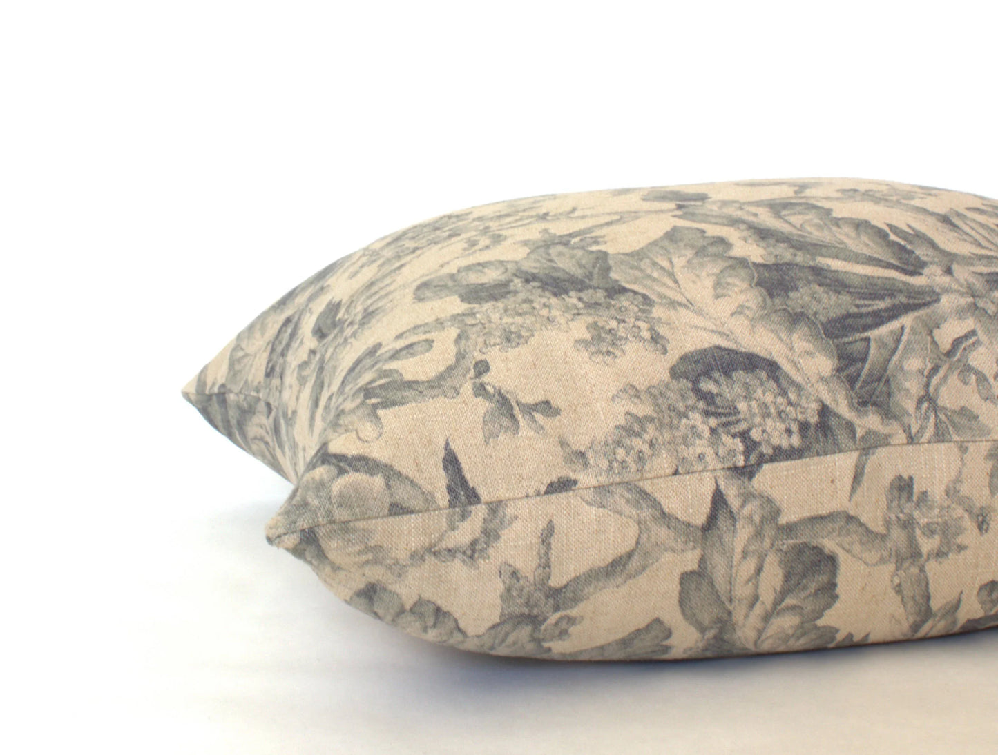 Decorative beige pillow with gray floral pattern on white background. Come see us at Awaken, Franklin, Tennessee