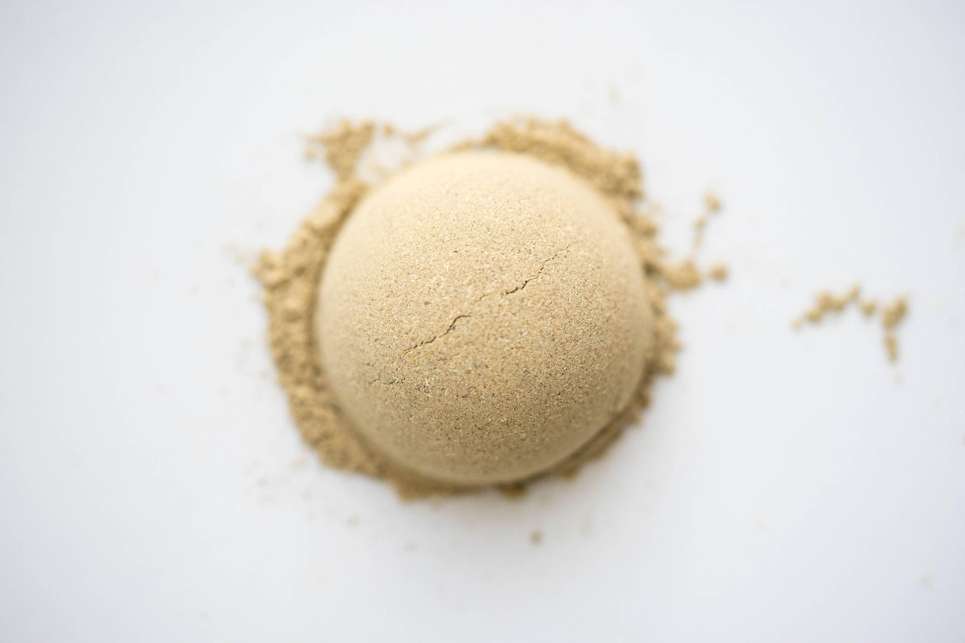 Close-up of a cracked tan powder mound on white surface, Come see us at Awaken, Franklin, Tennessee