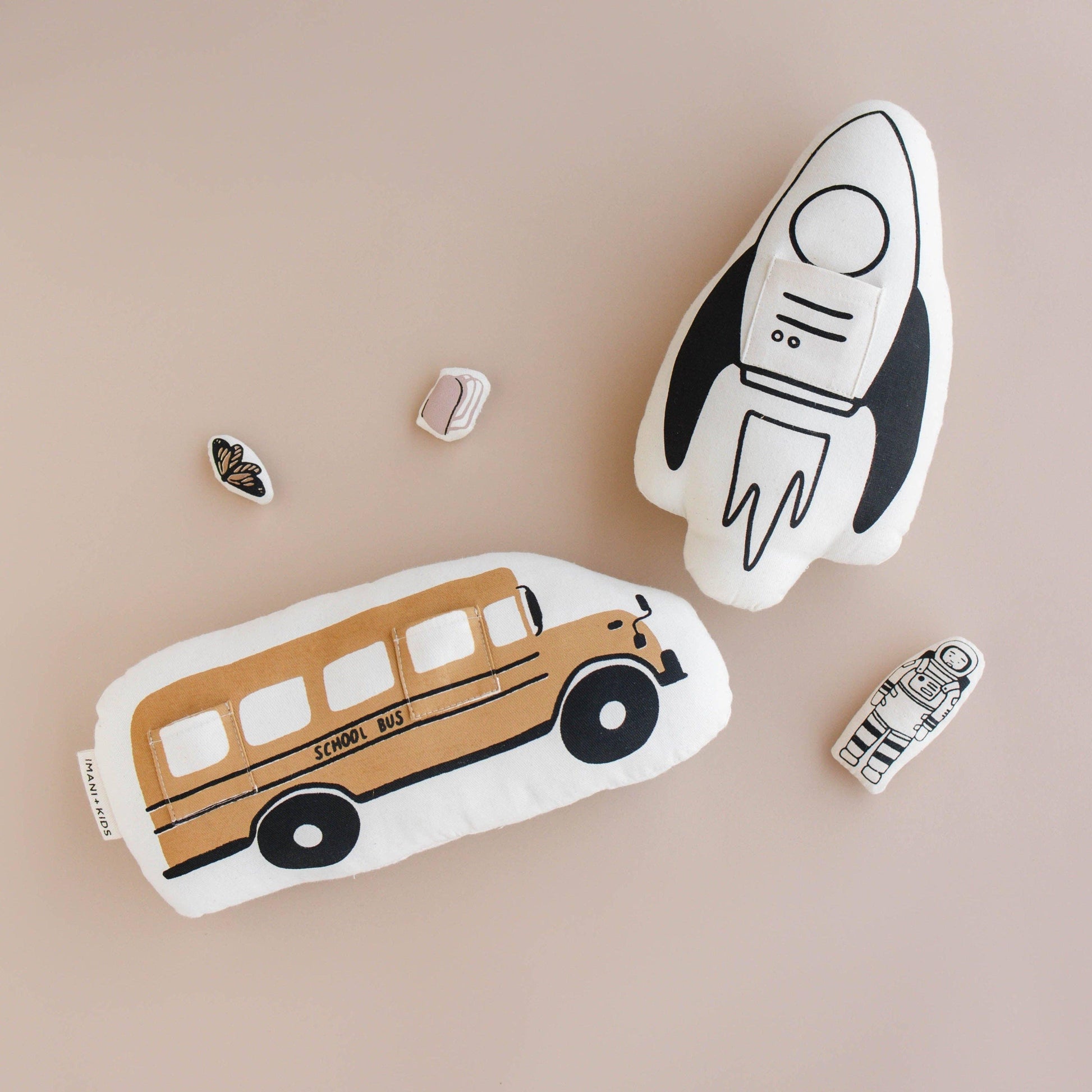 Plush school bus and rocket ship toys with astronaut, butterfly, book pins. Come see us at Awaken, Franklin, Tennessee