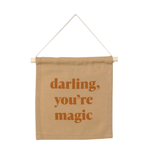 Tan fabric wall banner with 'darling, you're magic' text, Come see us at Awaken, Franklin, Tennessee.