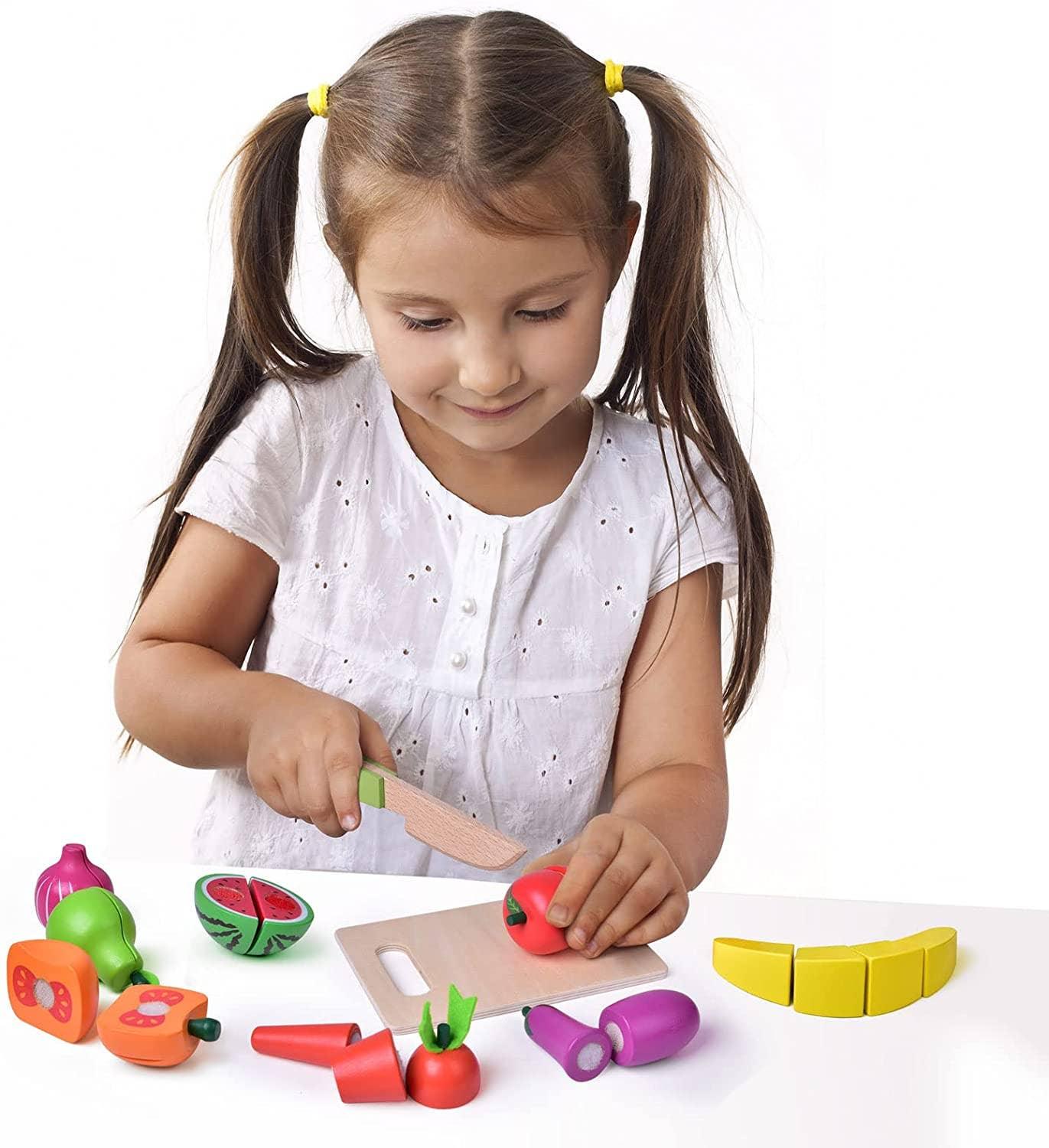 Girl slicing play fruits with toy knife on cutting board, Come see us at Awaken, Franklin, Tennessee