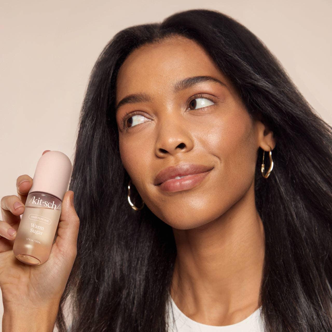 Woman with smooth skin holding Kitsch Warm Sugar serum, Come see us at Awaken, Franklin, Tennessee.