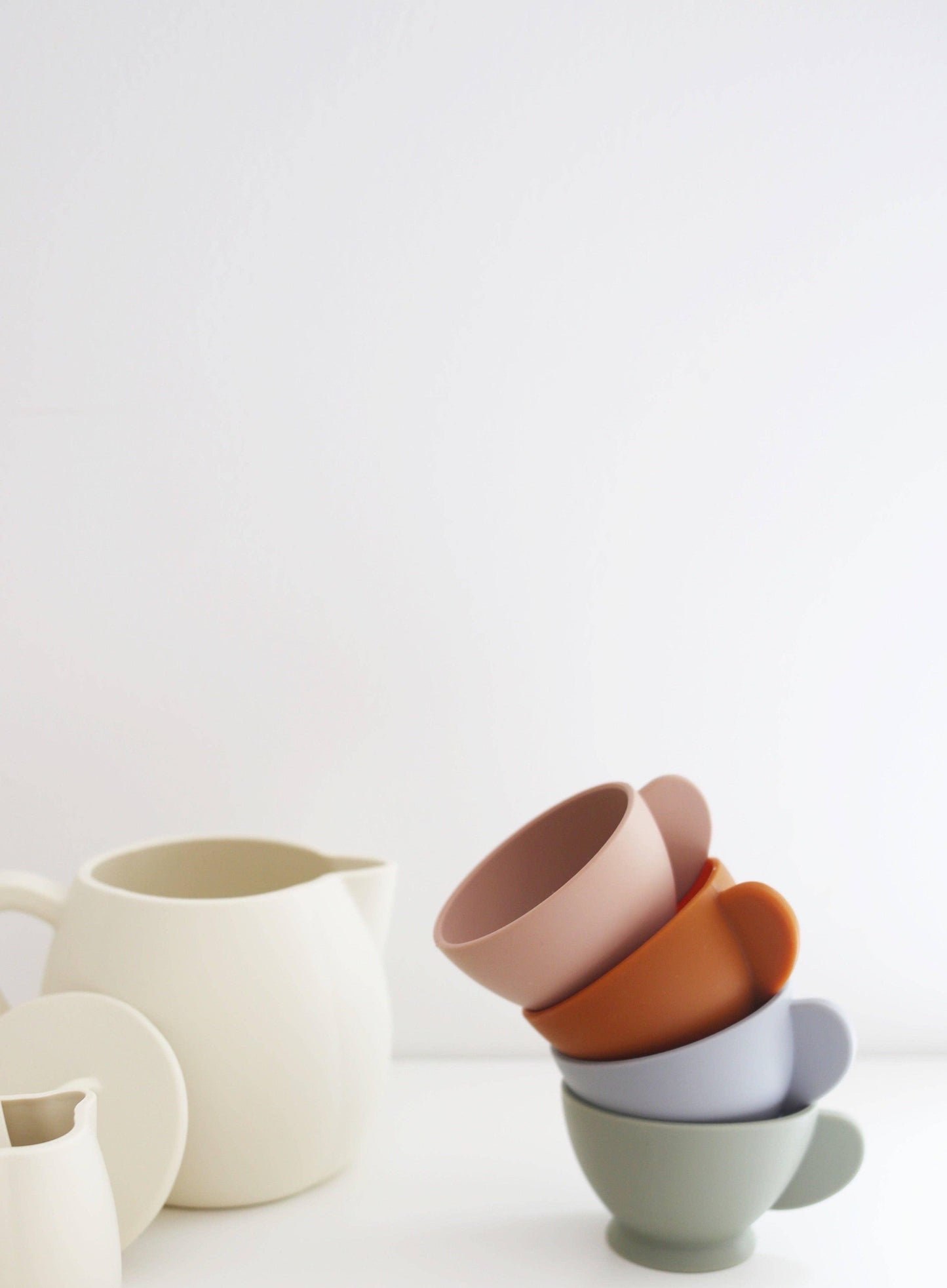 Stacked pastel ceramic cups and pitchers on white background, Come see us at Awaken, Franklin, Tennessee