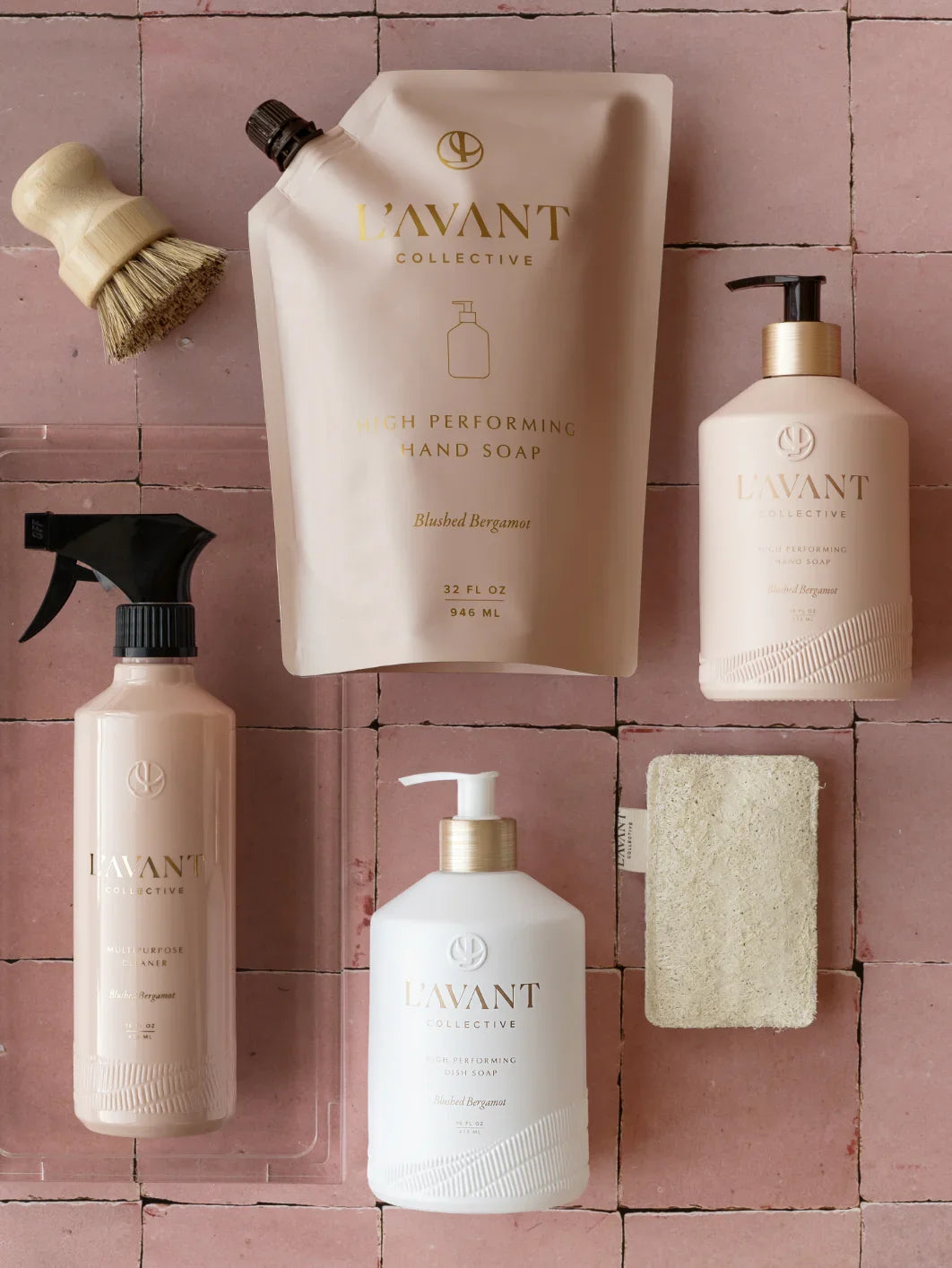 L’AVANT Collective hand soap, dish soap, cleaner, and scrub brush on pink tile, Come see us at Awaken, Franklin, Tennessee